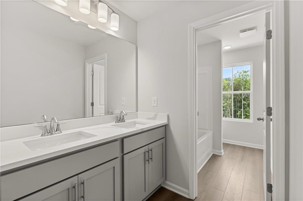 Modern bathroom with dual vanity and gray cabinets in The Burton A floor plan at The Bluffs in Canton, Georgia.