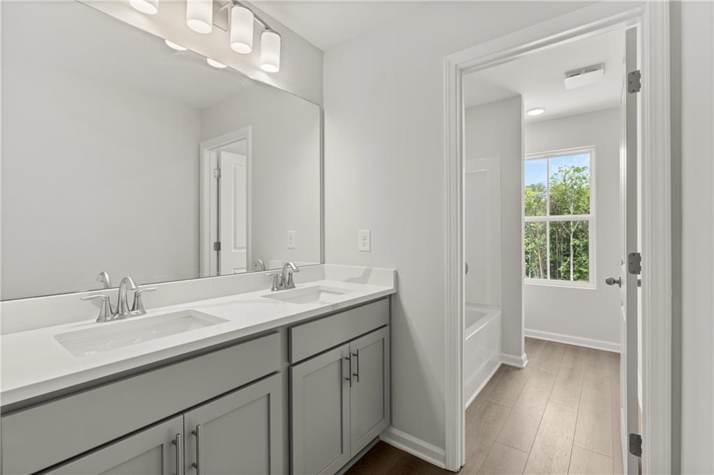Modern bathroom with dual vanity and gray cabinets in The Burton A floor plan at The Bluffs in Canton, Georgia.