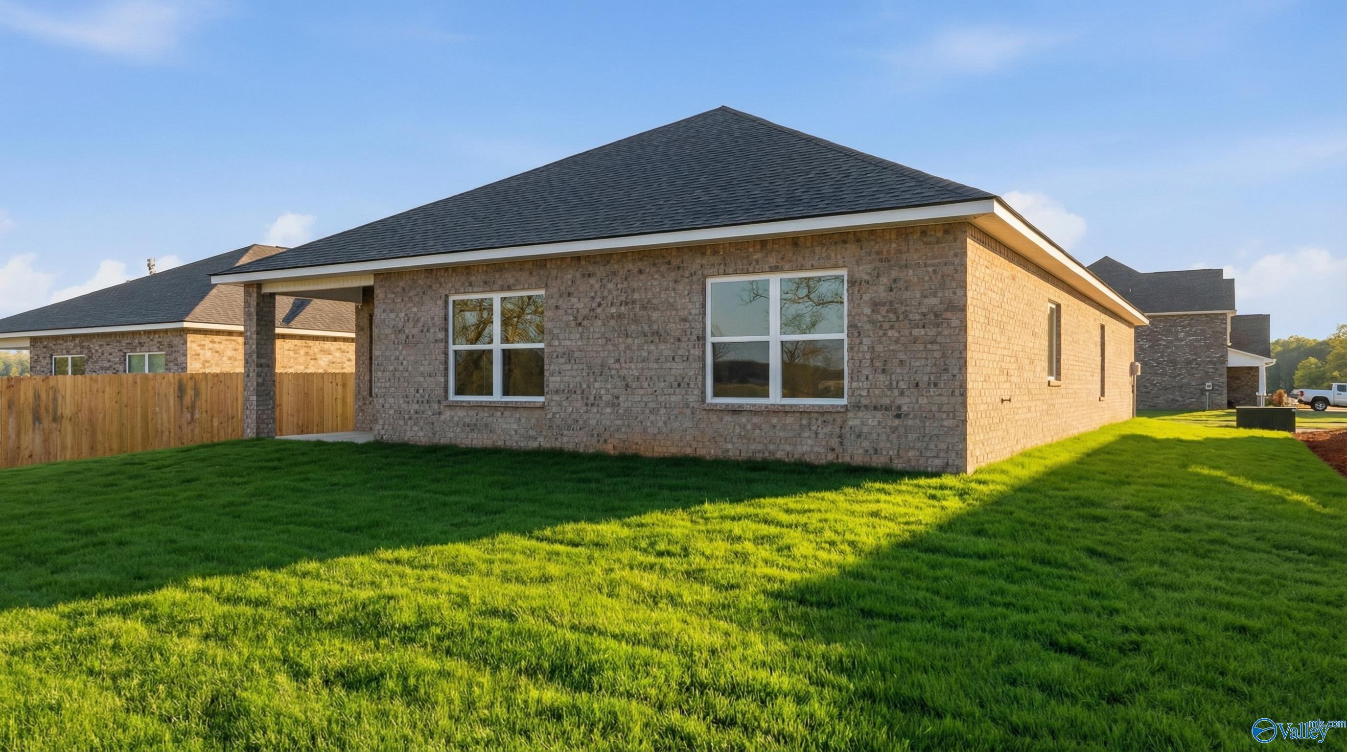 Brick single-story 4-bedroom home The Daphne C by Davidson Homes with shingled roof, large windows, and lush green lawn in Ivy Hills, Toney, Alabama