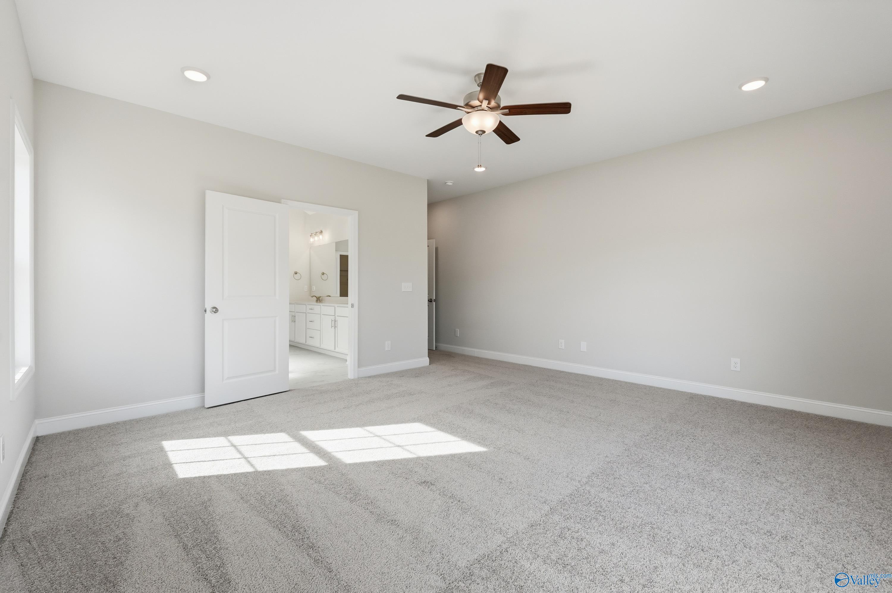 Spacious master bedroom with ceiling fan, en-suite bath and natural light in Davidson Homes The Finleigh, Harvest, AL