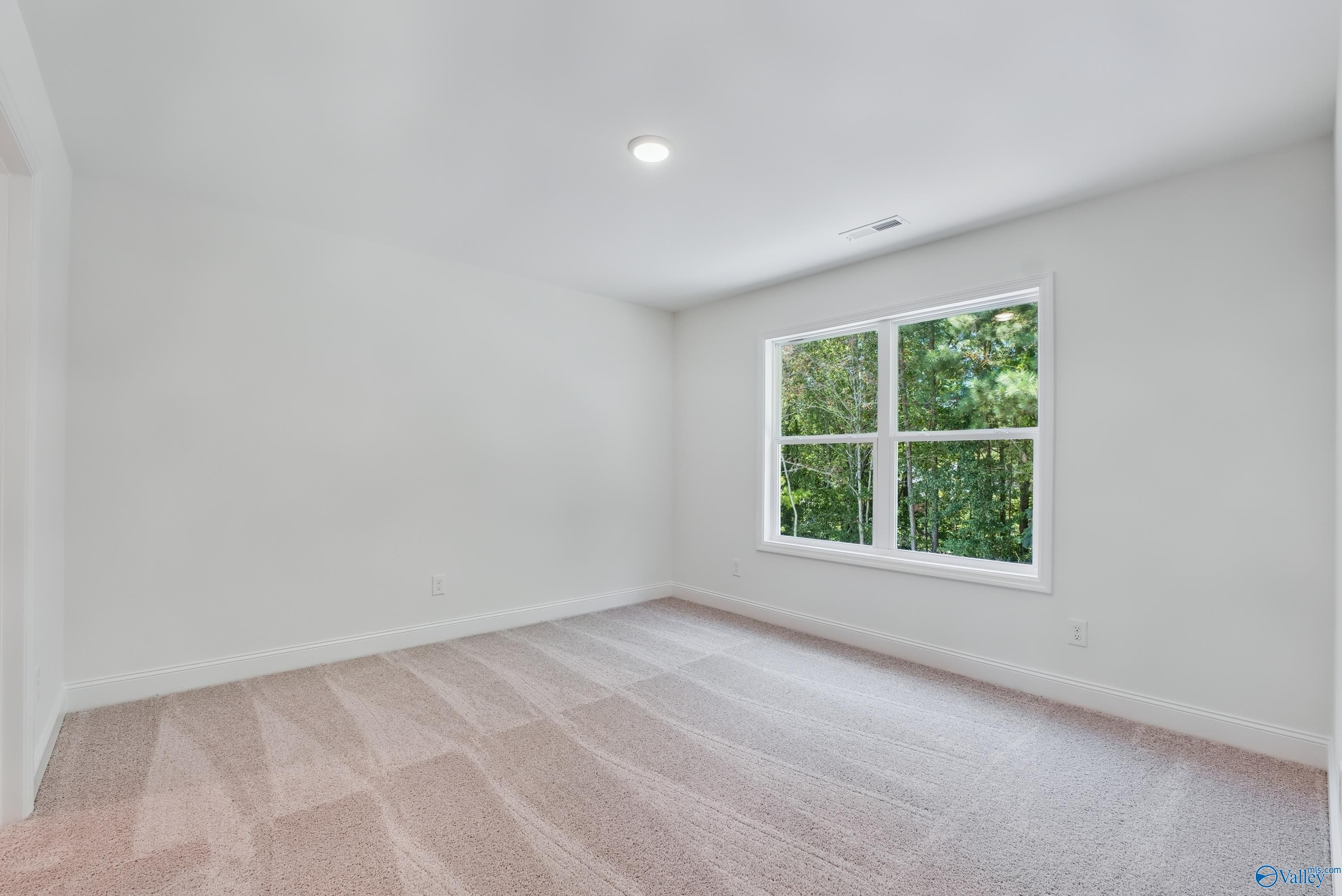 Bright secondary bedroom with large window overlooking lush greenery in The Shelby A 4-bedroom home, Arab, Alabama
