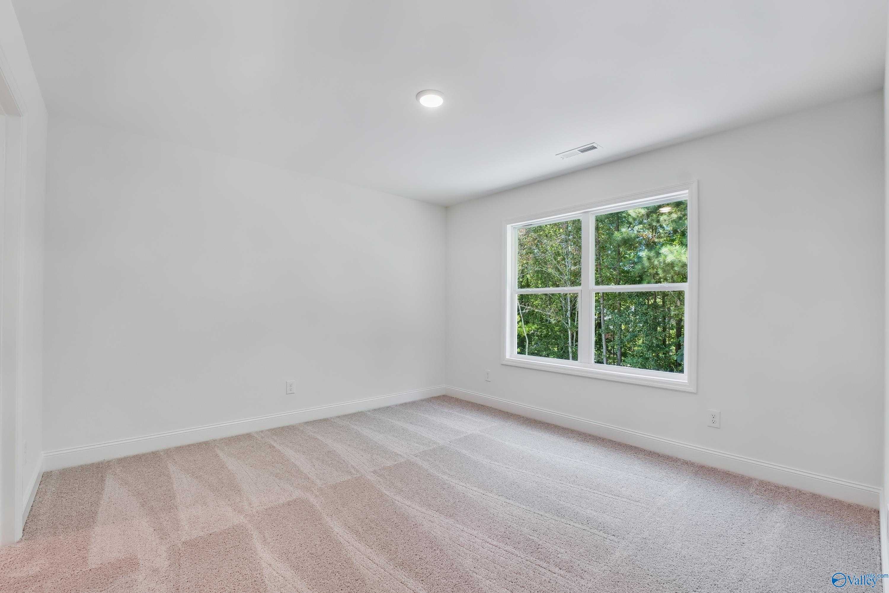 Bright secondary bedroom with large window overlooking lush greenery in The Shelby A 4-bedroom home, Arab, Alabama
