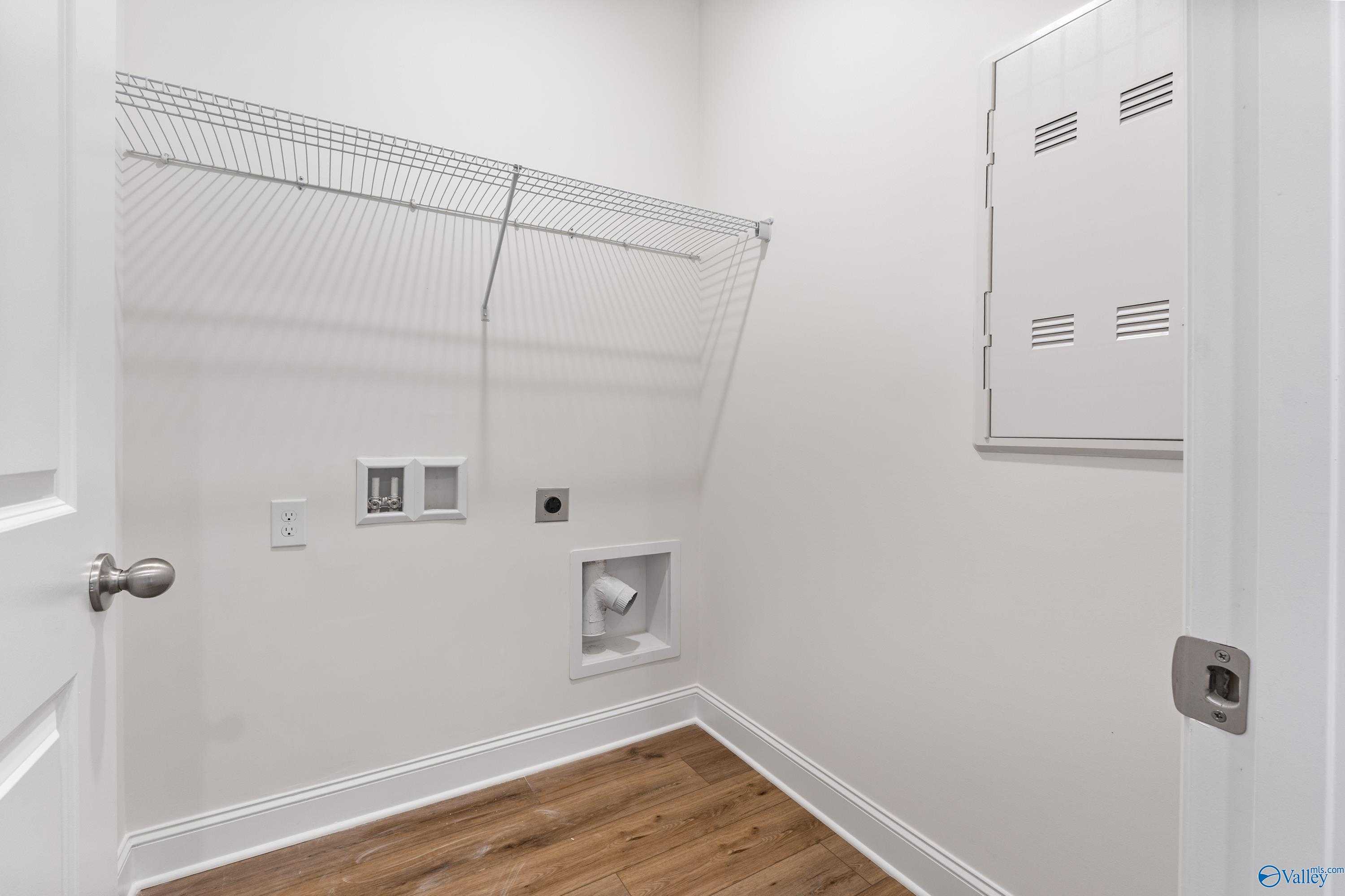 Spacious laundry room with wire shelving, washer dryer hookups, utility sink in Davidson Homes The Asheville C, New Market, Alabama