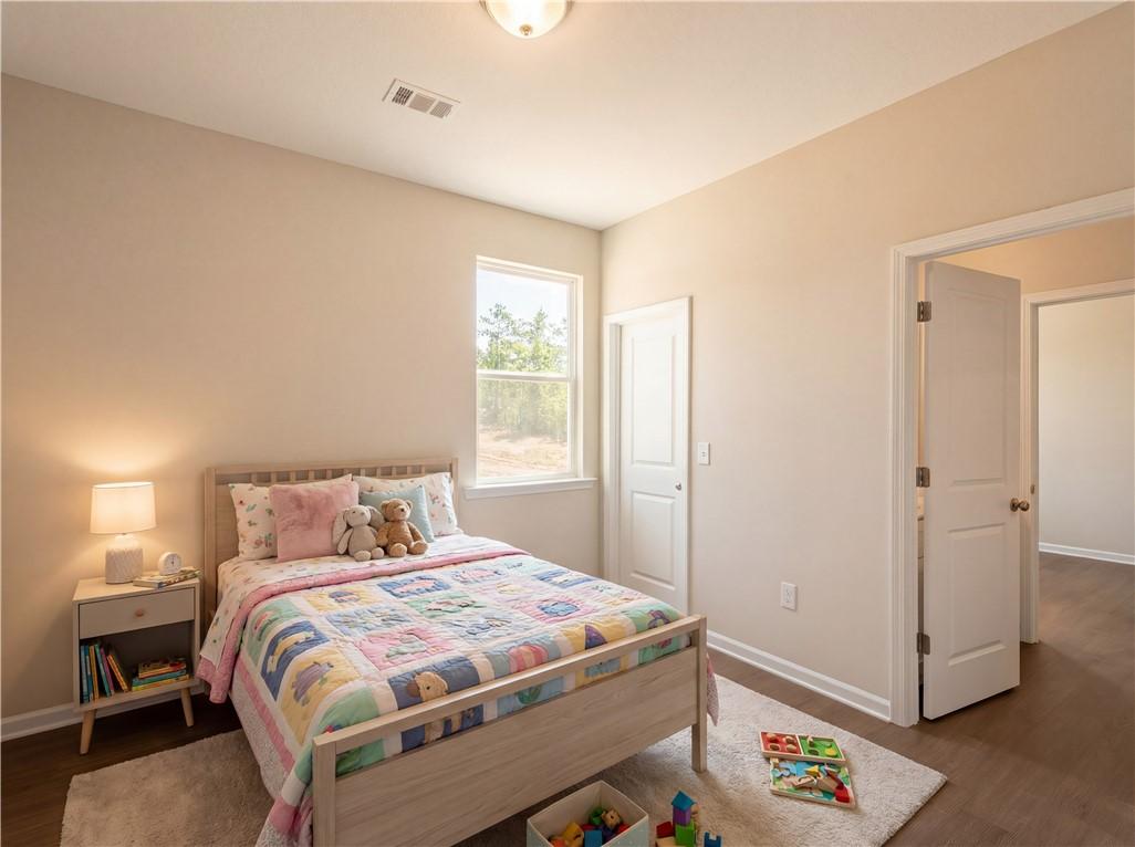 Cozy children's bedroom with elephant quilt bed, teddy bear, toys and beige walls in Evermore Homes The Orion, Cusseta, Alabama