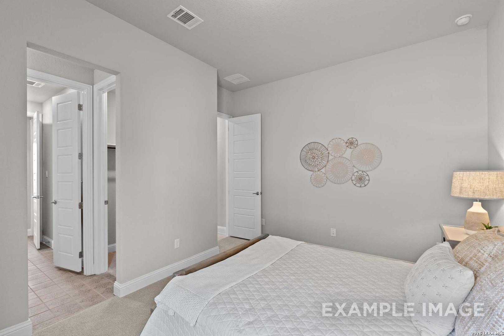 Cozy bedroom featuring neutral decor in The Garner C floor plan at The Reserve at Potranco Oaks in Castroville, Texas.