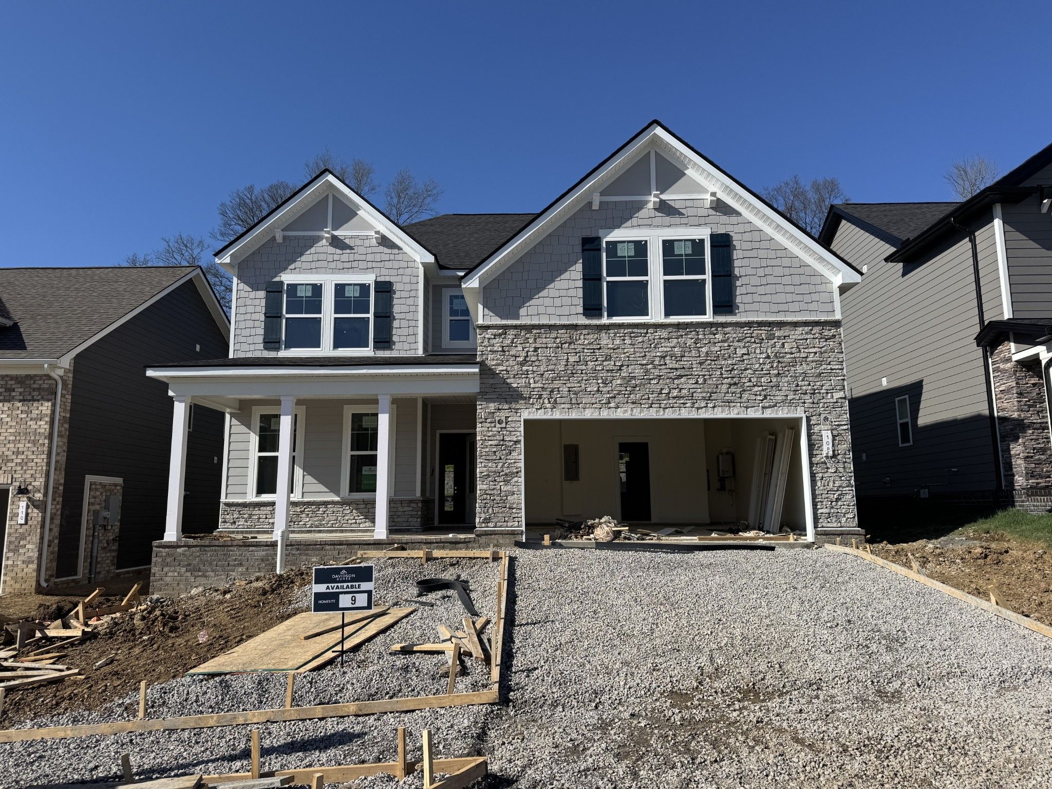 Modern two-story stone-and-siding home with two-car garage and front porch in Woods Crossing, Gallatin, Tennessee by Davidson Homes The Willow