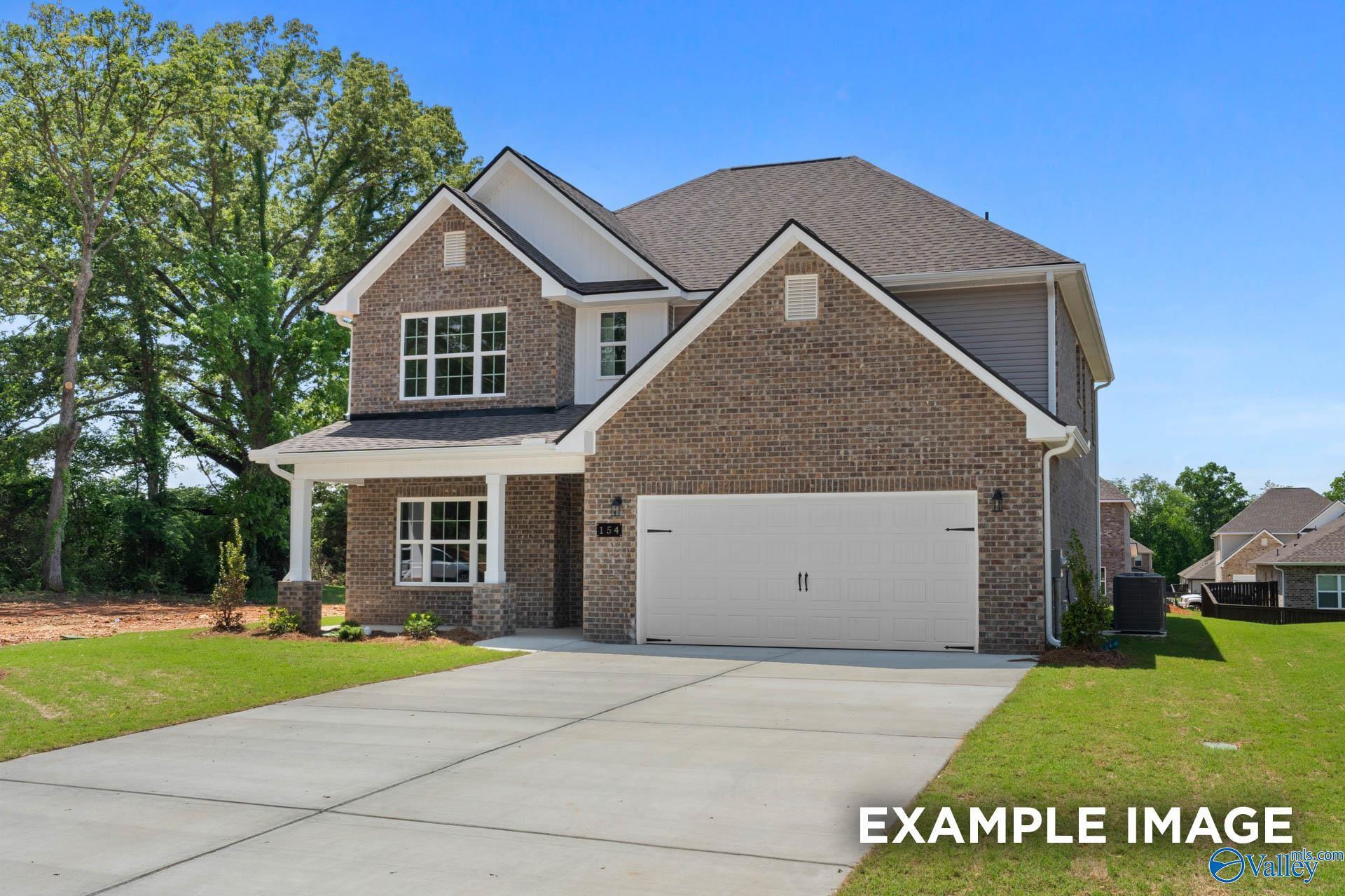 Two-story brick home with two-car garage, covered porch, and green lawn in Walker's Hill, Meridianville, Alabama