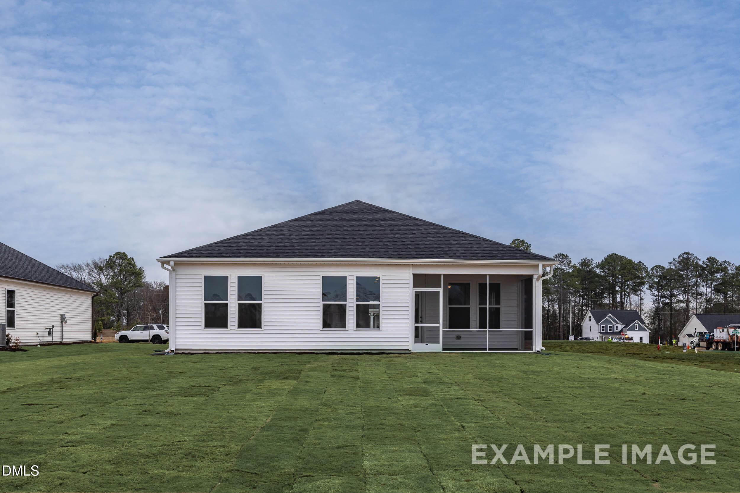 Rear exterior view of The Franklin C floor plan by Davidson Homes with a screened patio in Retreat at North Main, Lillington.