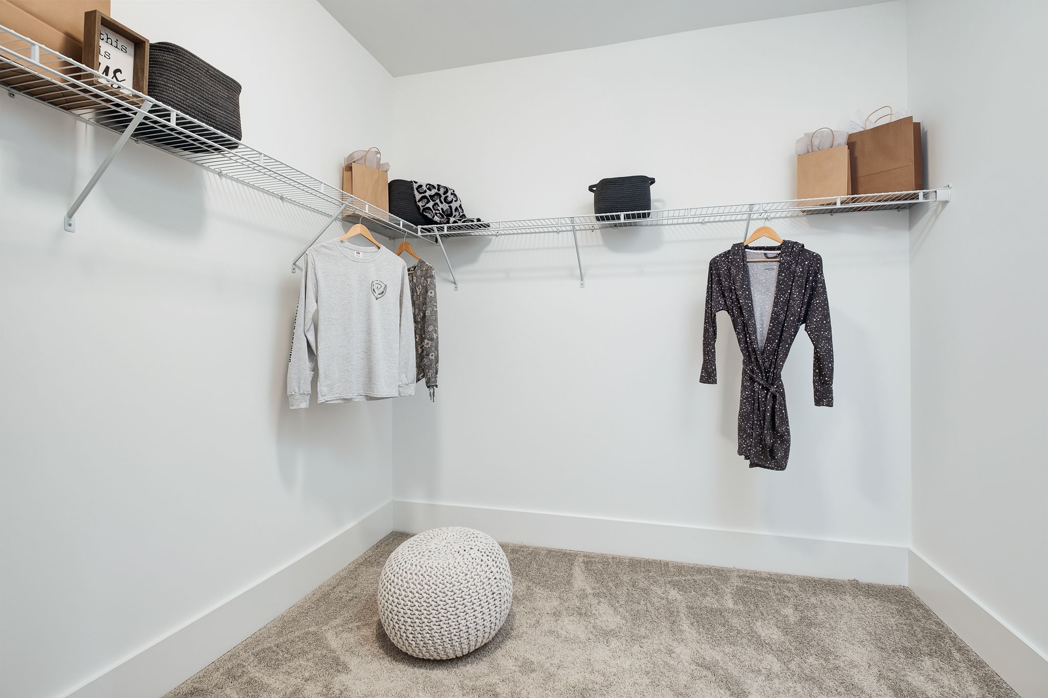 Spacious walk-in closet in Chimney Creek home at Hampton Cove Alabama with wire shelving, hanging clothes, and storage bins