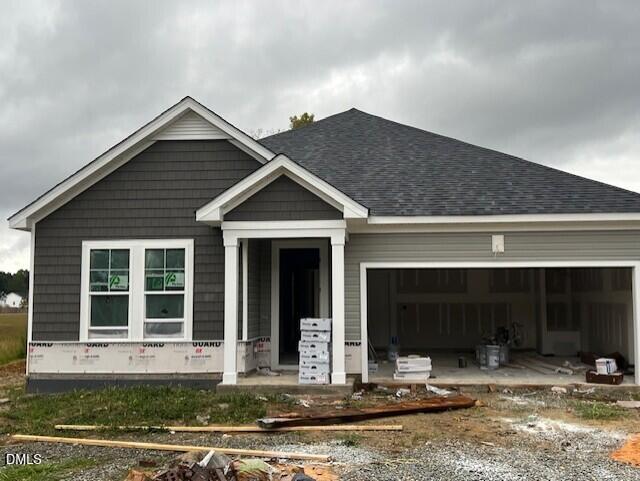 New construction single-story home with gray siding and 2-car garage under construction at Wellers Knoll, Lillington, North Carolina