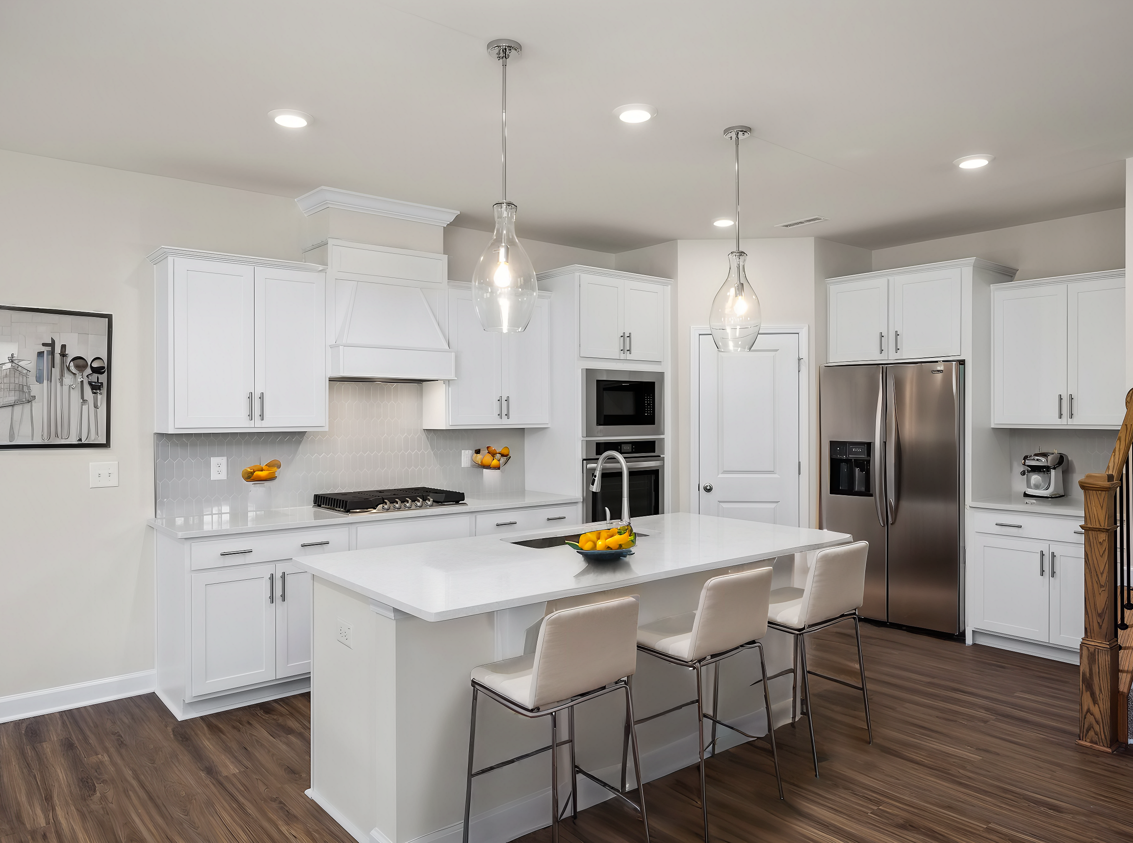 Spacious white kitchen with quartz island, bar stools, stainless appliances at Wendell Ridge, Wendell NC by Davidson Homes