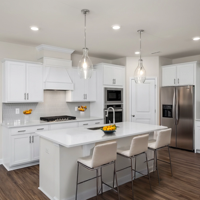 Spacious white kitchen with quartz island, bar stools, stainless appliances at Wendell Ridge, Wendell NC by Davidson Homes