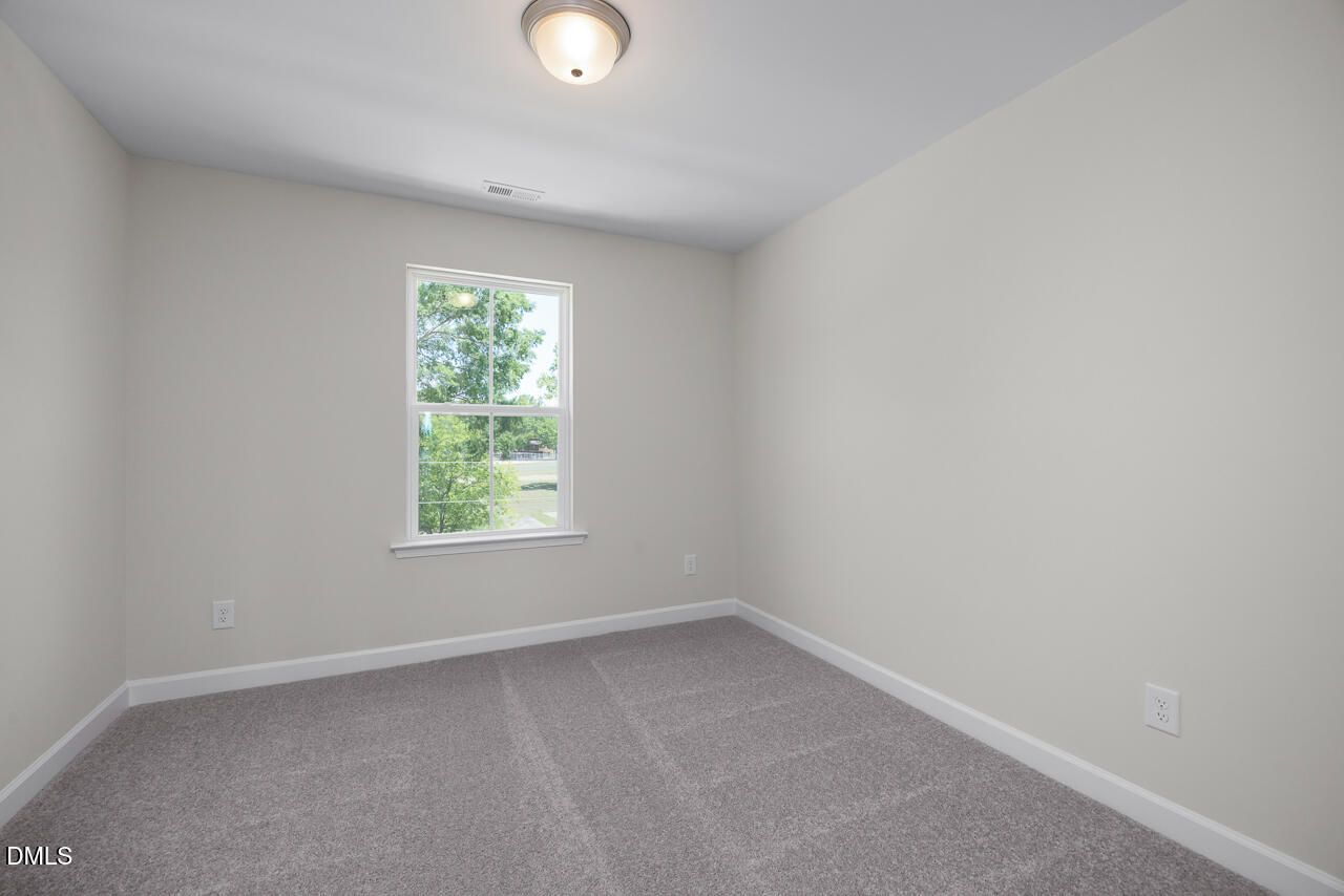Bright, neutral-toned bedroom with plush carpet in The Mitchell floor plan at Camden Park, Knightdale, North Carolina.