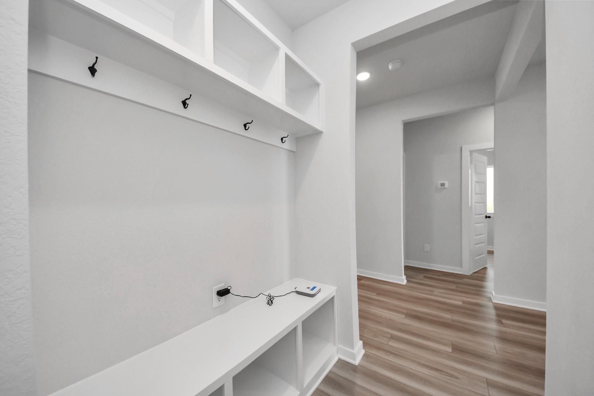 Mudroom with white cubby storage, coat hooks, and bench in Davidson Homes Everett C floor plan at River Ranch Meadows, Dayton, Texas