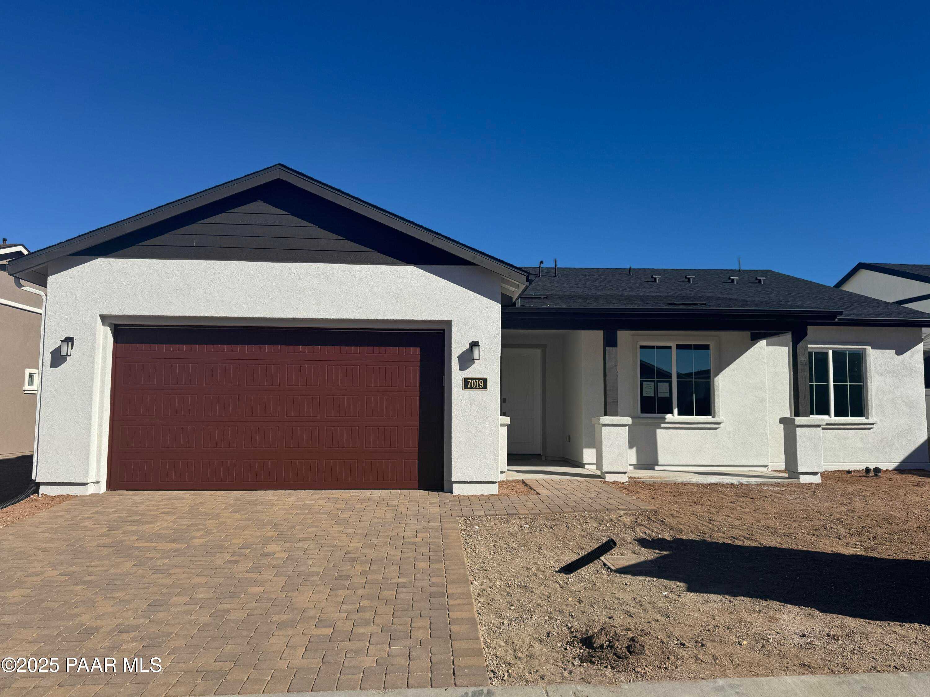 Modern 1-story 2-bedroom home with 2-car garage, red door, white stucco exterior in Westwood, Prescott, Arizona - Davidson Homes Summit A
