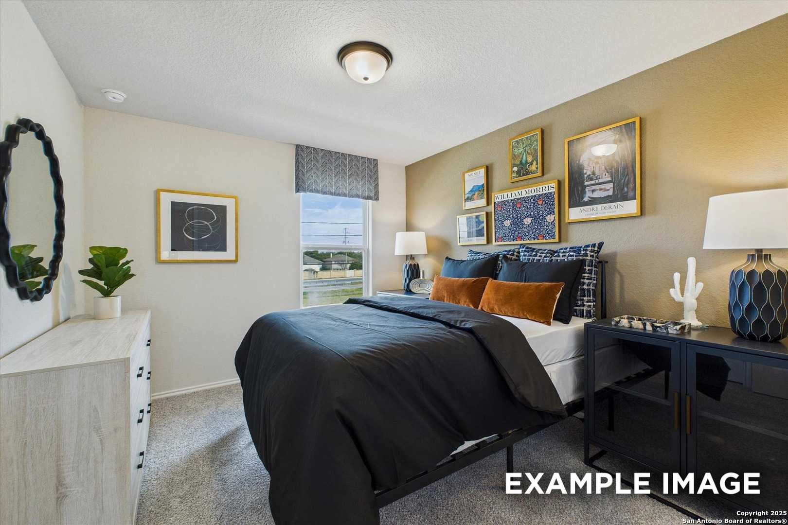 Cozy bedroom with beige walls, queen bed in dark linens, orange pillows, framed art, and window view in Davidson Homes The Florence C, San Antonio