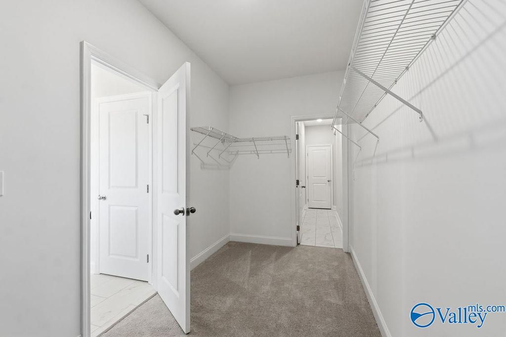 Spacious walk-in closet with wire shelving and rods in master suite, The Harrison floor plan by Davidson Homes in Hartselle, Alabama