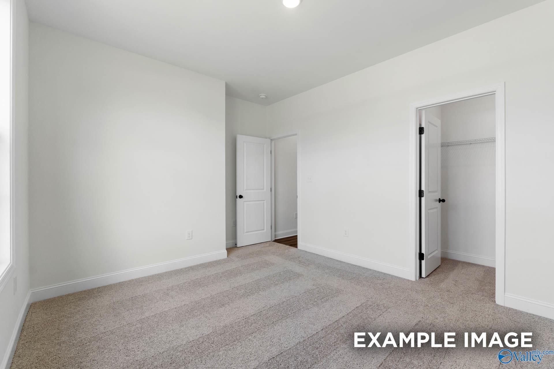 Spacious carpeted bedroom with walk-in closet in The Rockford B floor plan by Davidson Homes in Briercreek, Meridianville.
