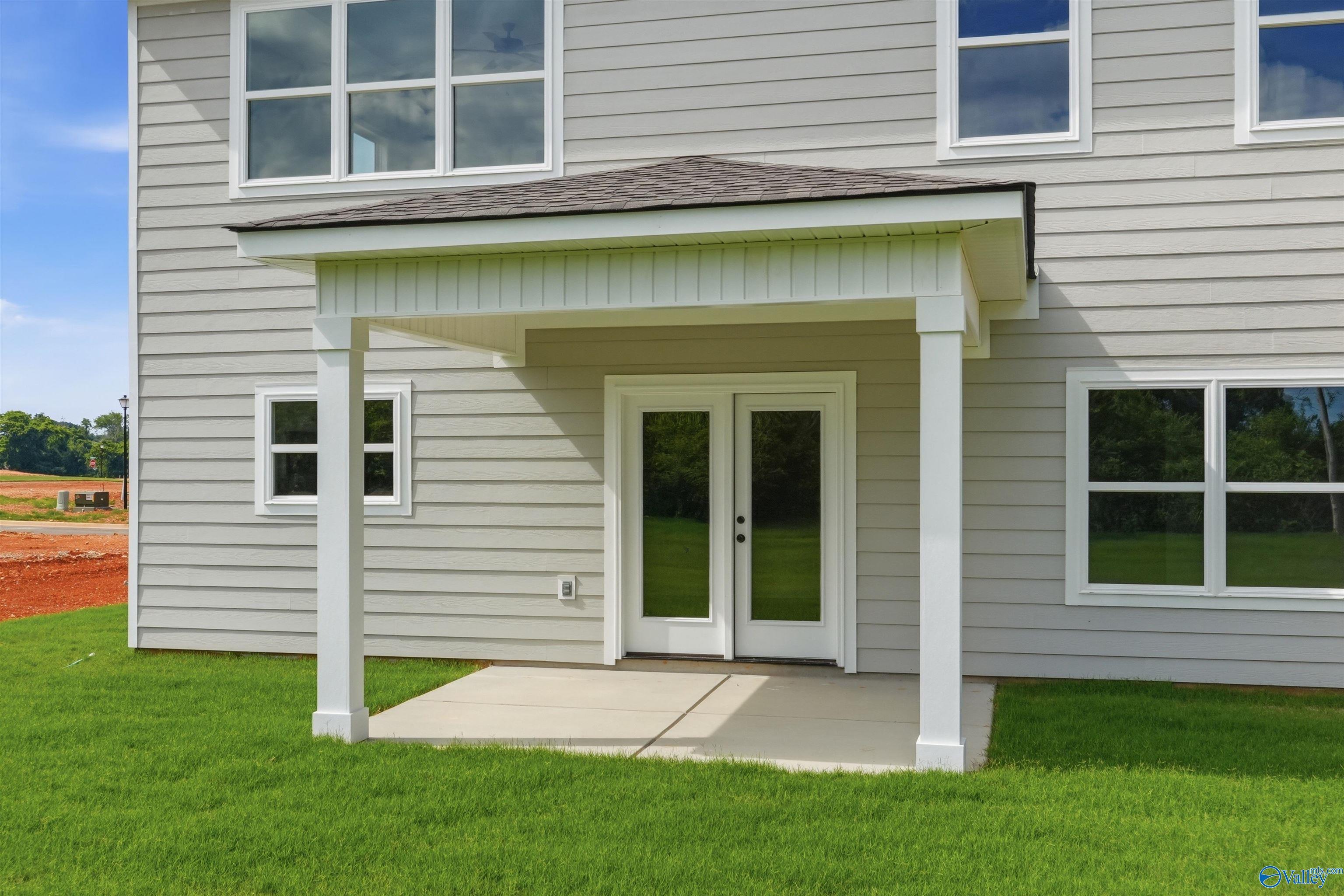 Covered patio with French doors on the exterior of a Chelsea D floor plan home in Berry Cove, New Market, Alabama.