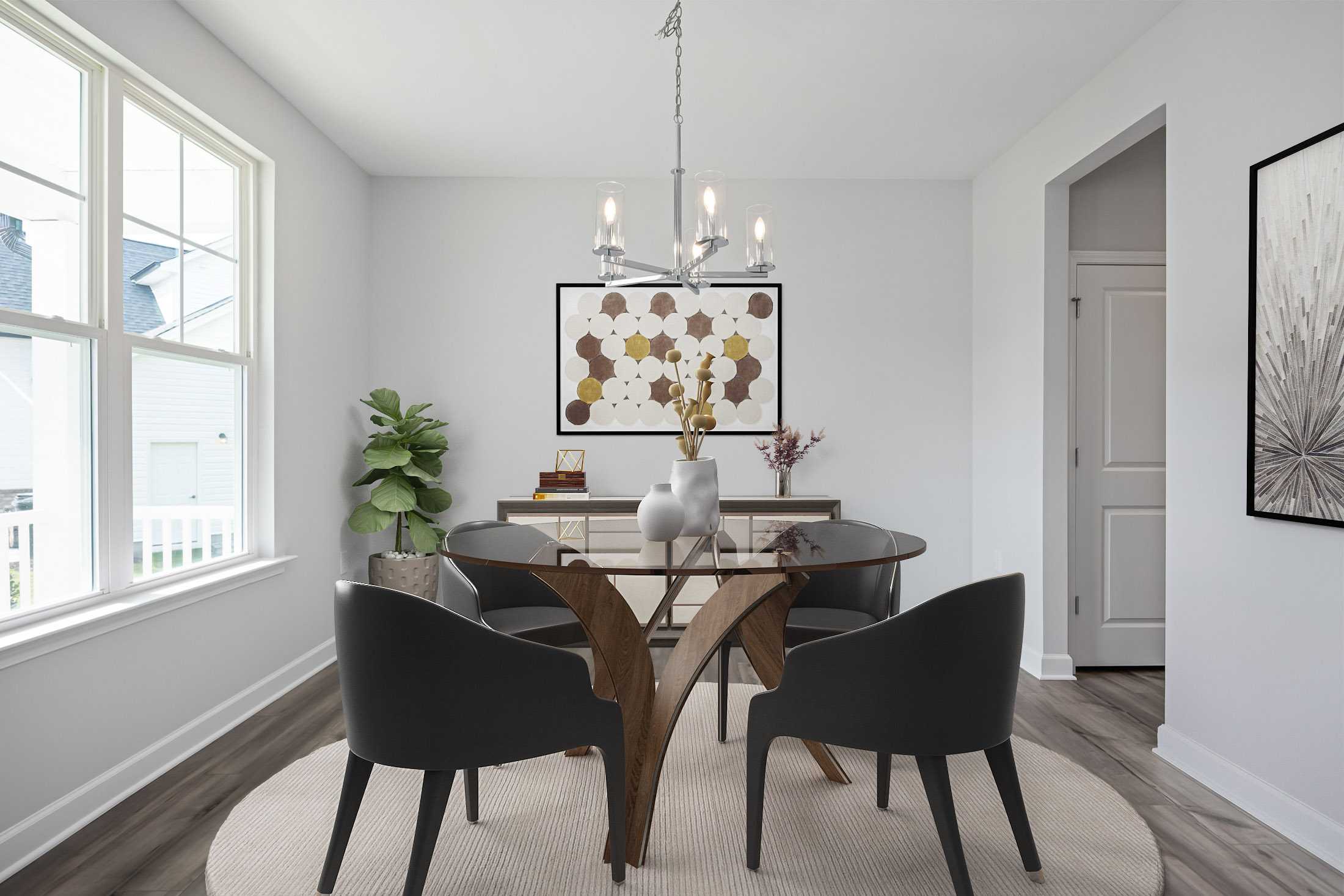 Elegant dining room at Stagecoach Corner in Mebane NC with glass table, black chairs, modern chandelier, and abstract art