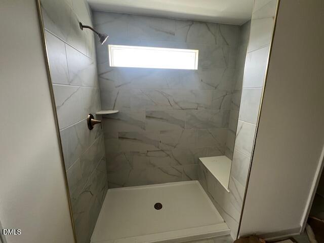 Walk-in shower with marble-look tile and built-in bench in Hickory II B floor plan at Retreat at North Main, Lillington, NC.