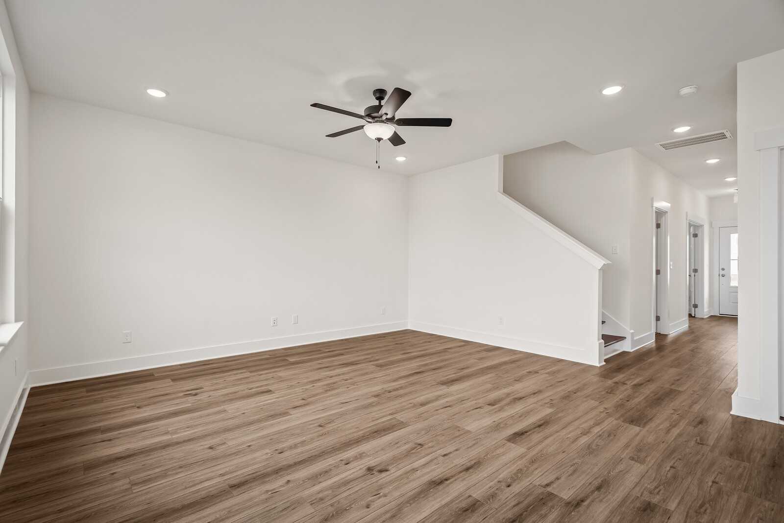Spacious foyer with hardwood floors, ceiling fan, and staircase in The Logan C 3-bedroom home, Gallatin, Tennessee