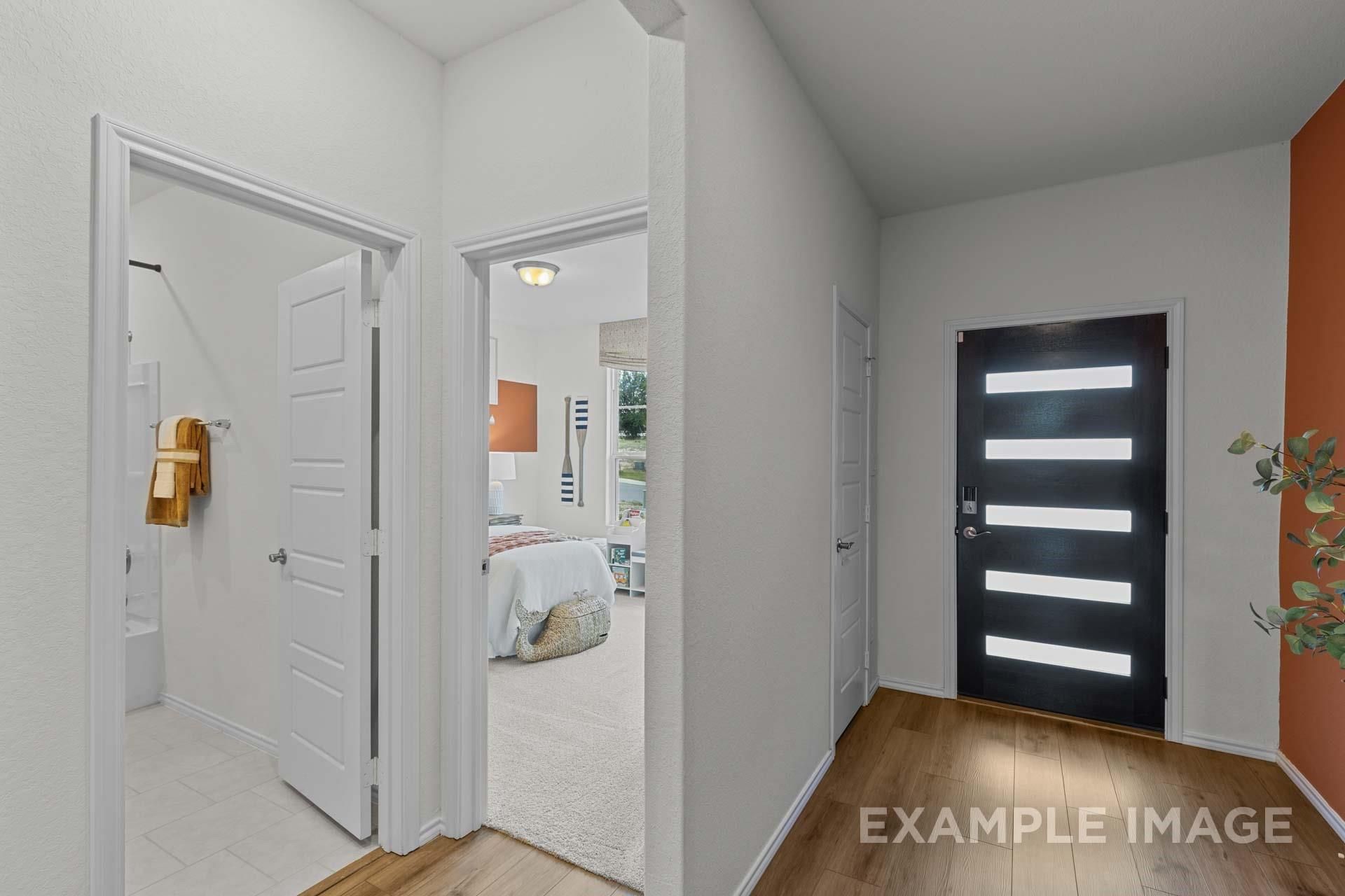 Modern entryway with black front door leading to bedroom and bathroom in The Daphne F plan at Sundance Cove, Crosby, TX.