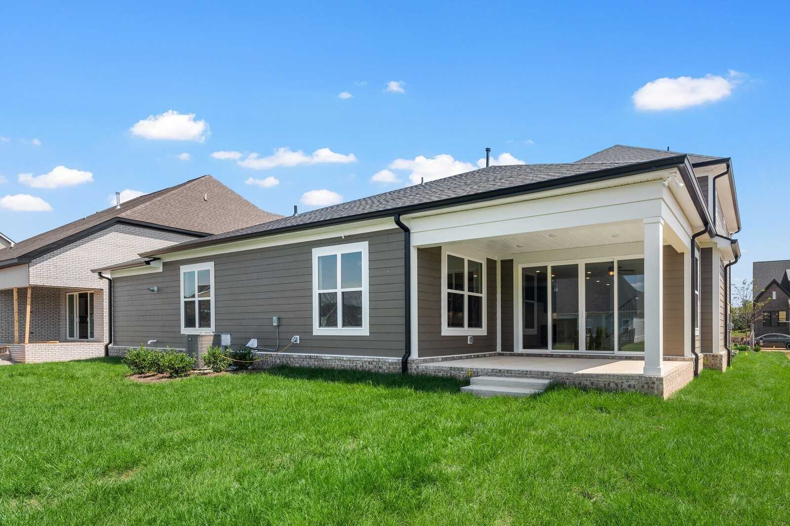 Gray two-story home with covered rear patio, glass doors, and lush green yard in Shelton Square, Murfreesboro, Tennessee