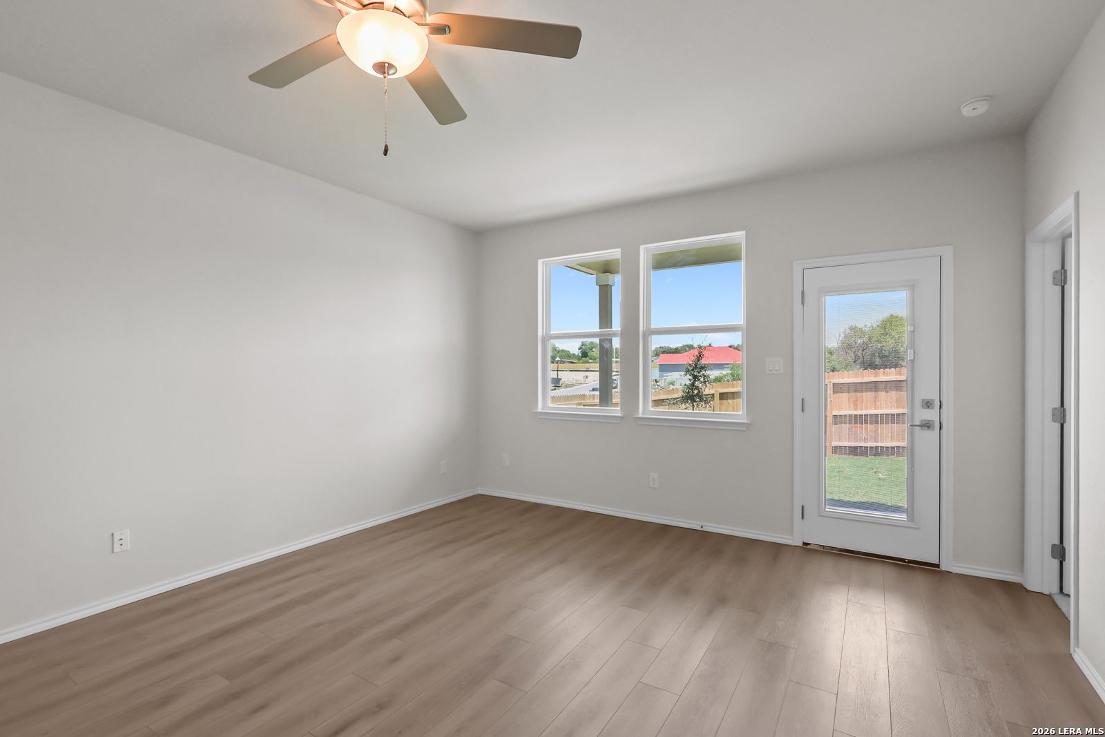 Bright bedroom with wood-look flooring and backyard access in The San Marcos F floor plan by Davidson Homes, San Antonio.