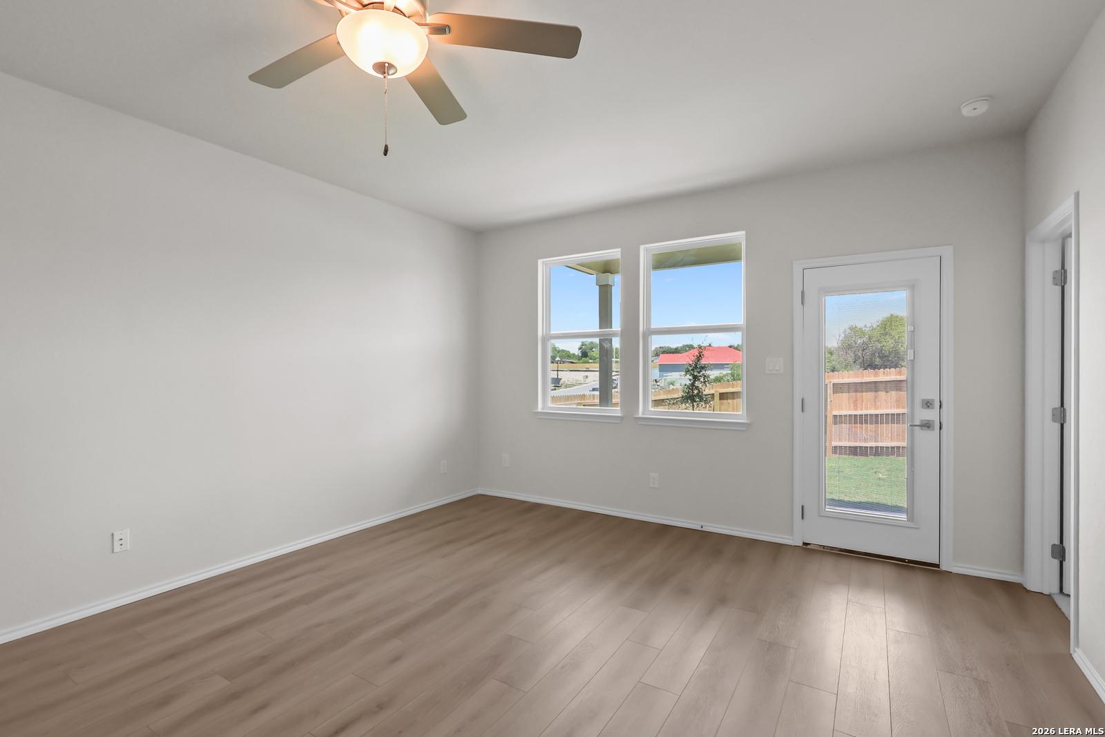 Bright bedroom with wood-look flooring and backyard access in The San Marcos F floor plan by Davidson Homes, San Antonio.