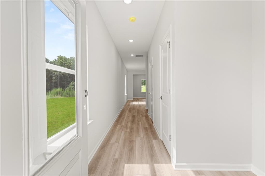 Bright, airy foyer with wood-look flooring at The Russell A floor plan in Cedar Farms, Winder, Georgia.