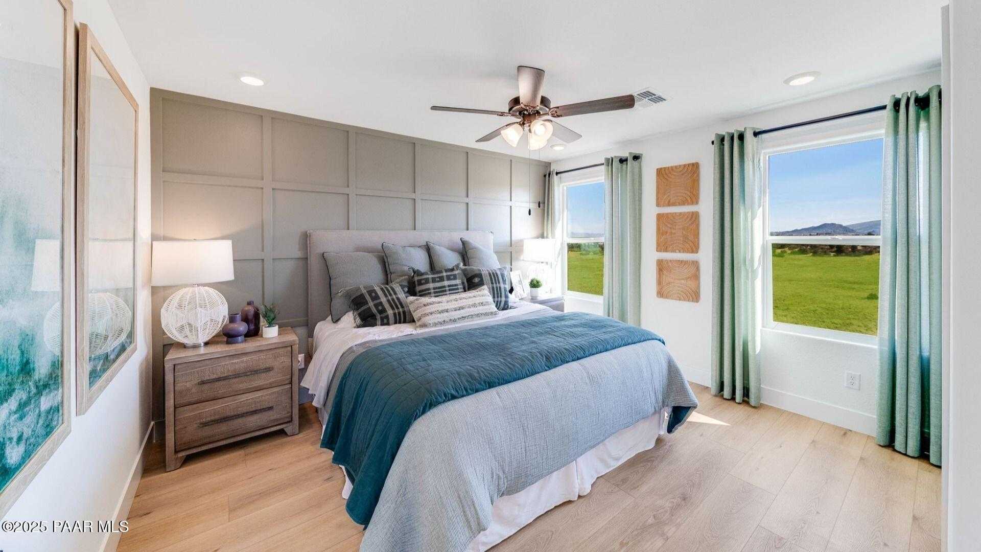 Cozy master bedroom with king bed, blue duvet, ceiling fan, and valley views in Davidson Homes Wilmington B, Prescott AZ