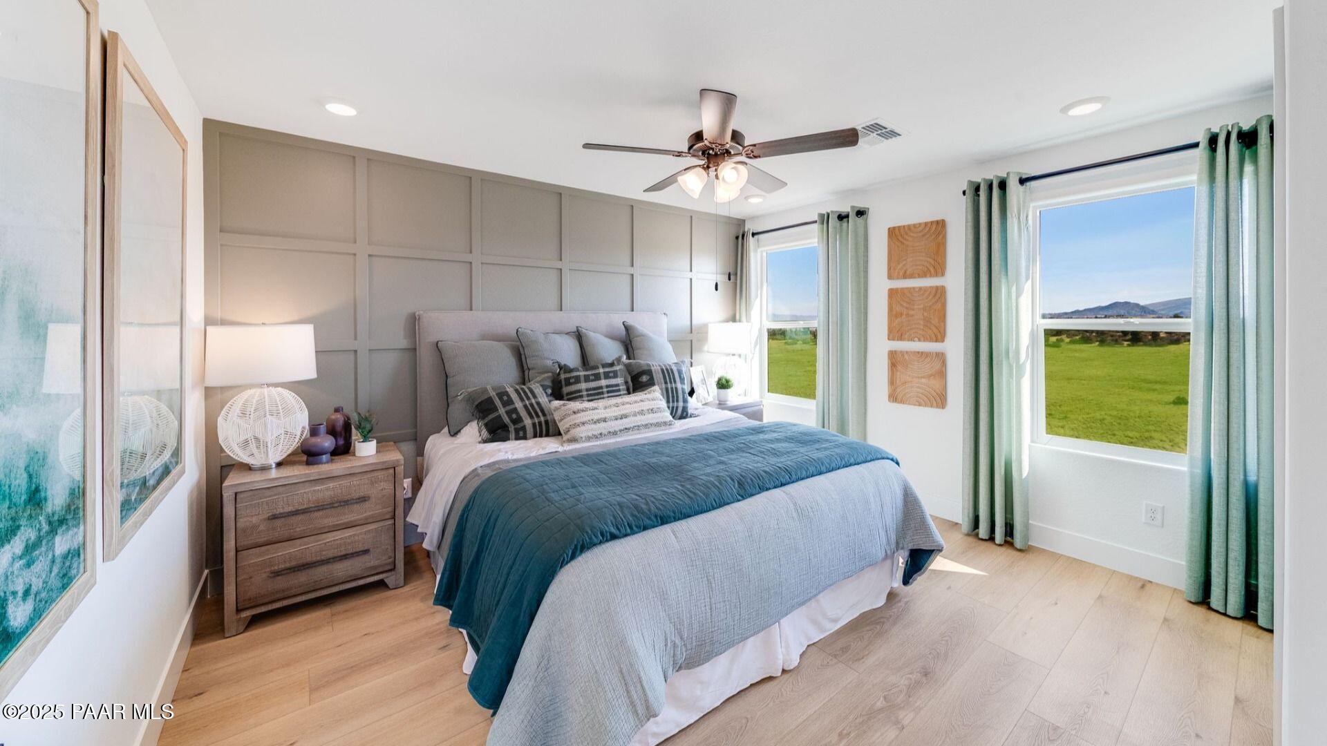 Cozy master bedroom with king bed, blue duvet, ceiling fan, and valley views in Davidson Homes Wilmington B, Prescott AZ