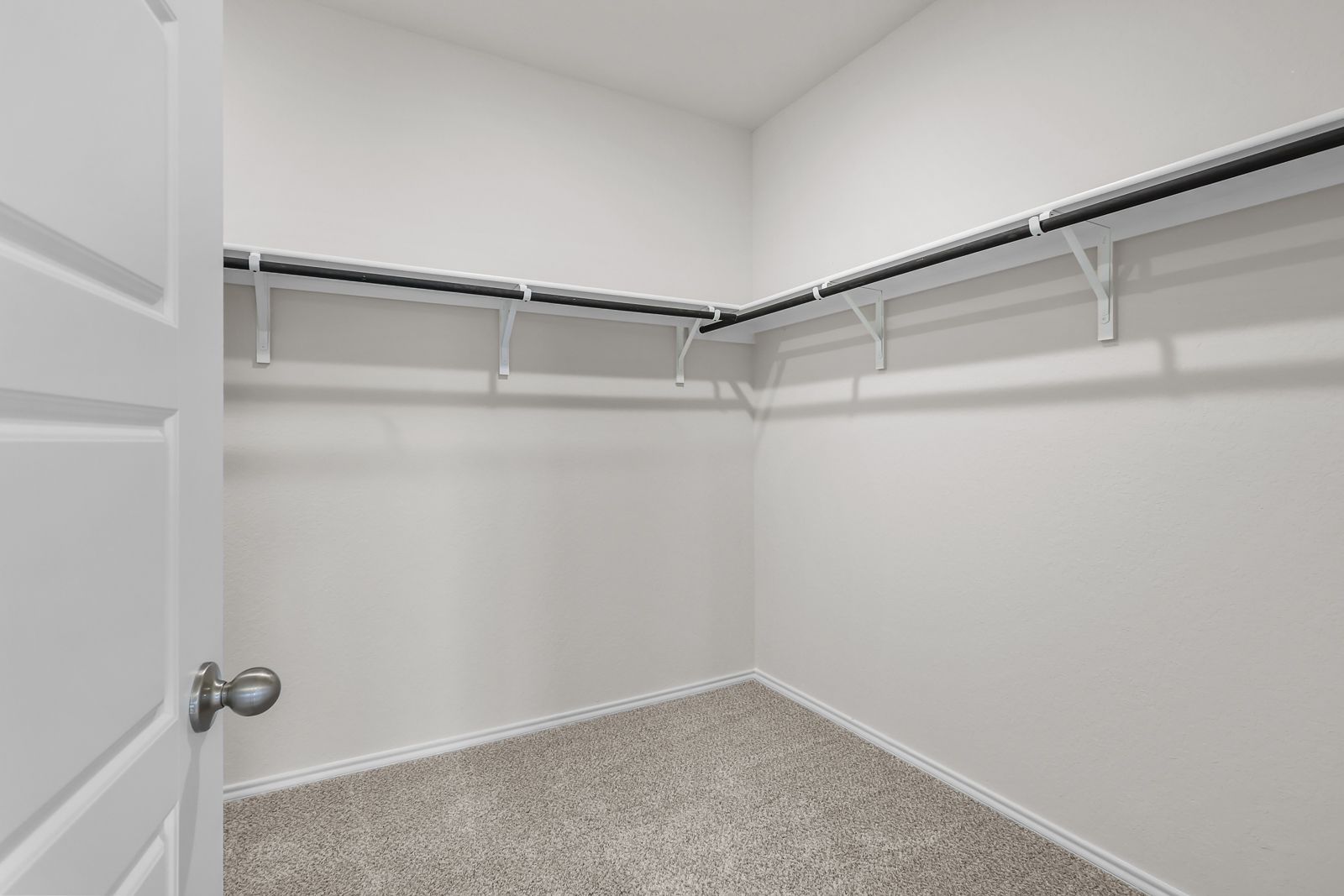 Spacious walk-in closet in The Sequoia C featuring ample shelving and hanging rods for organized storage.