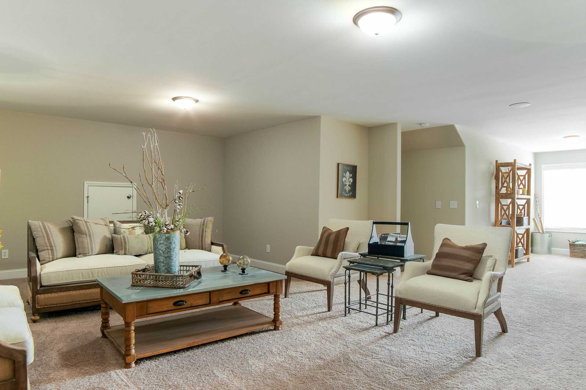 Spacious family room at The Dairy at Oak Grove in South Huntsville AL with beige sofas wooden coffee table and open bookshelves
