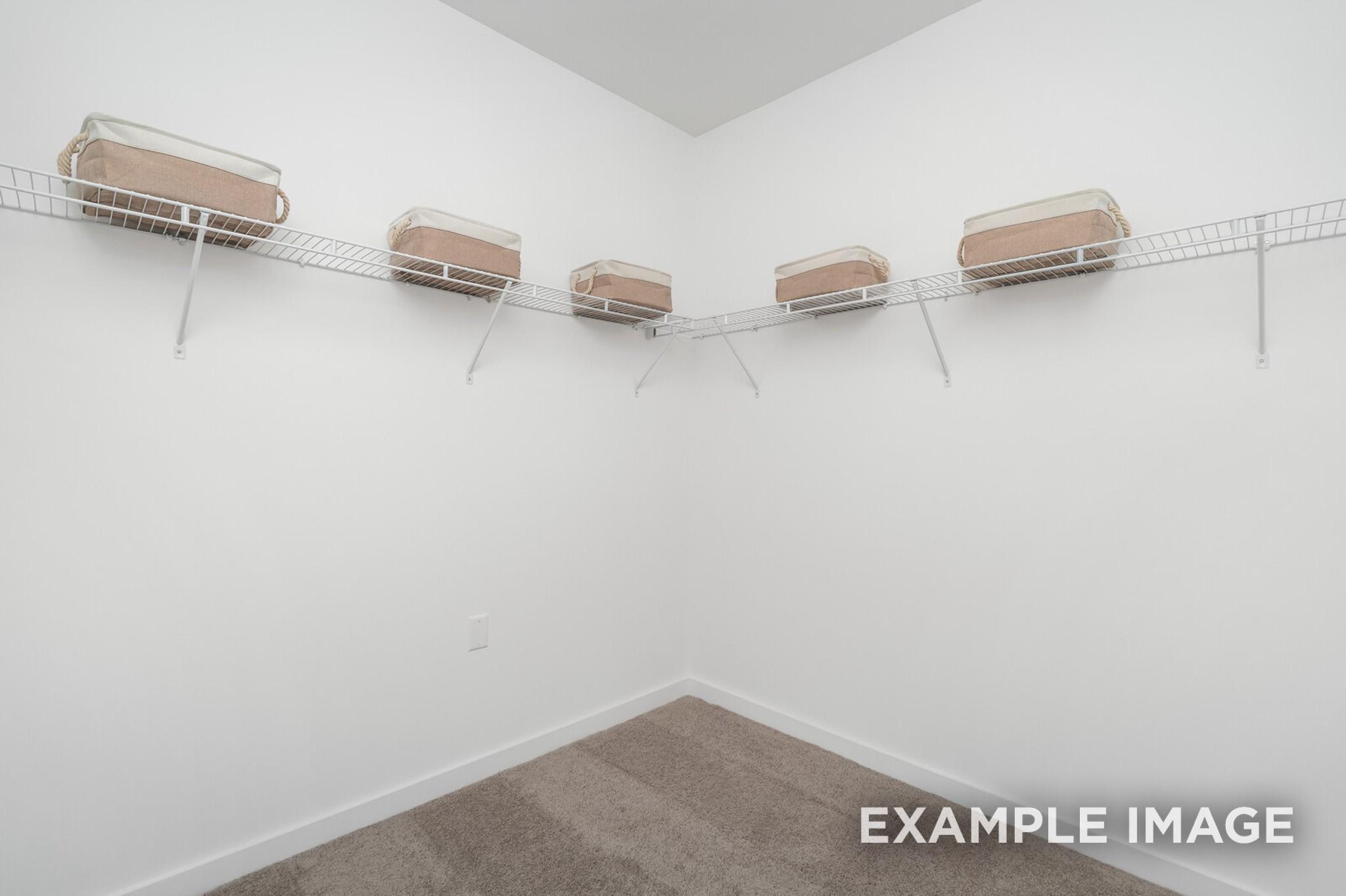 Walk-in closet with white wire shelving and storage bins in The Ash A floor plan at Woods Crossing, Gallatin, Tennessee.