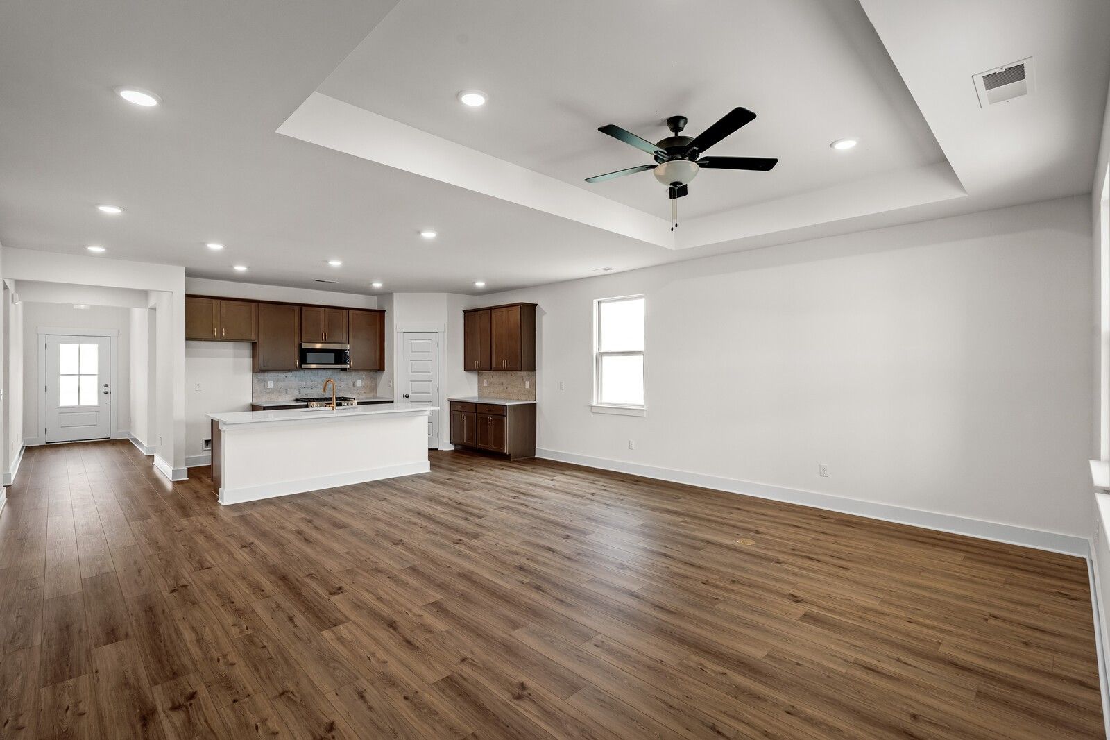 Open-concept kitchen and living area with tray ceiling in The Prairie C floor plan at Woods Crossing, Gallatin, TN.