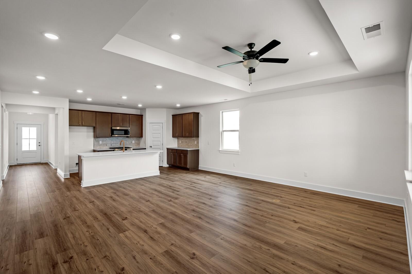Open-concept kitchen and living area with tray ceiling in The Prairie C floor plan at Woods Crossing, Gallatin, TN.