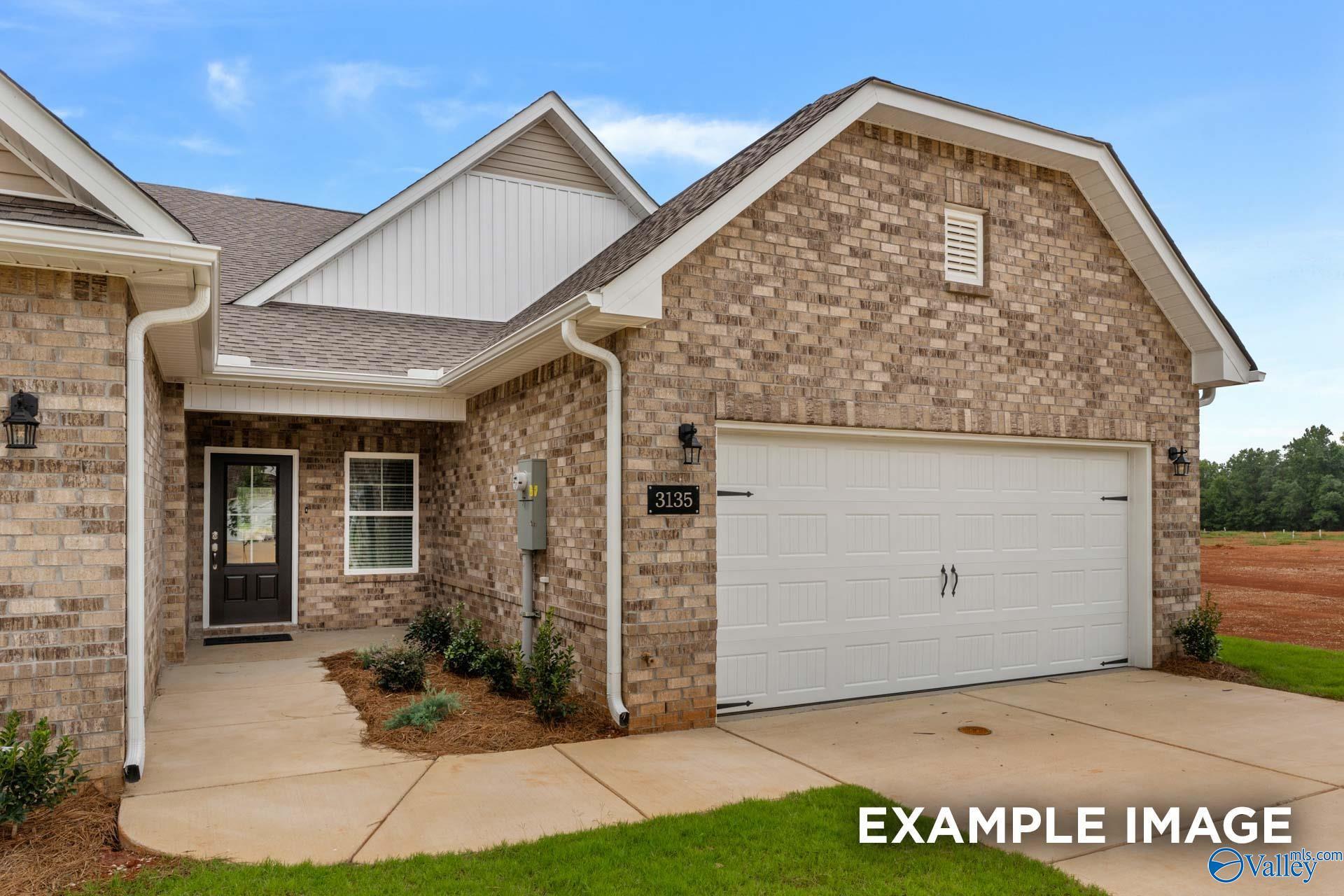 Brick single-story home with 2-car garage, front entry, and landscaping in The Retreat at Hollon Meadow, Decatur, Alabama