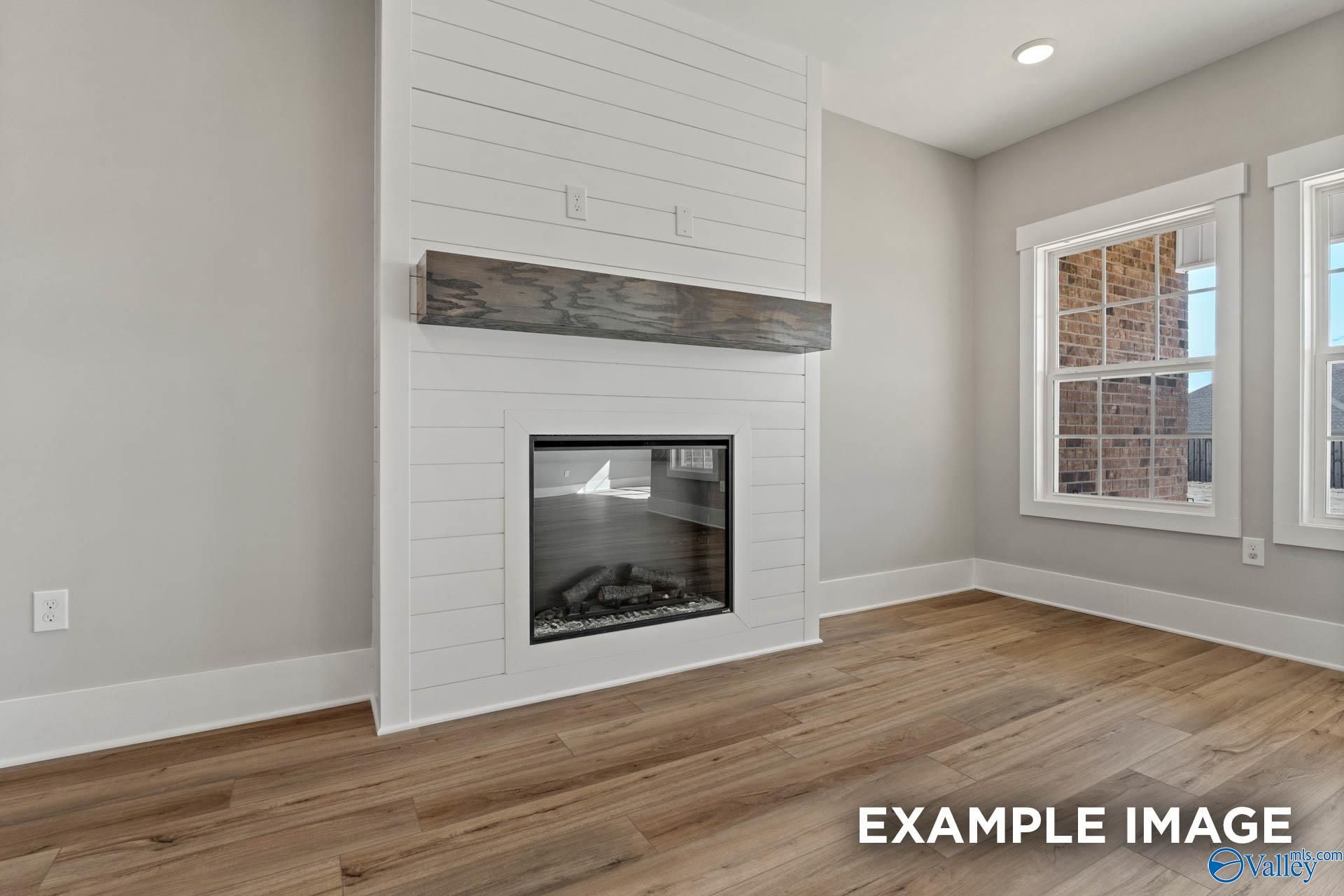 Modern fireplace with shiplap surround and wood mantel in The Finleigh floor plan by Davidson Homes in Meridianville, AL.