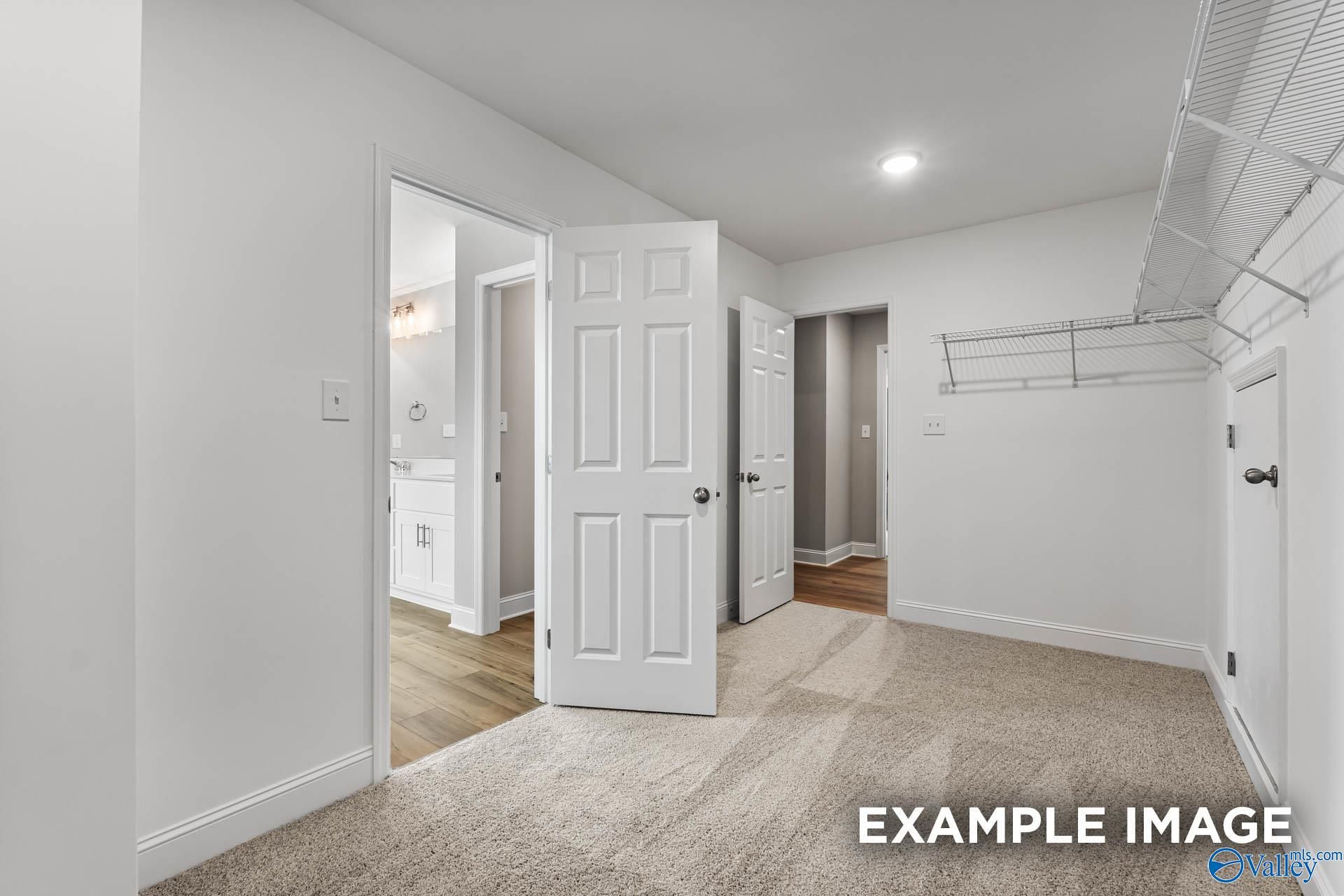 Spacious laundry room with wire shelving, open doors to bathroom and bedroom in Davidson Homes Chelsea B, Ivy Hills Toney AL
