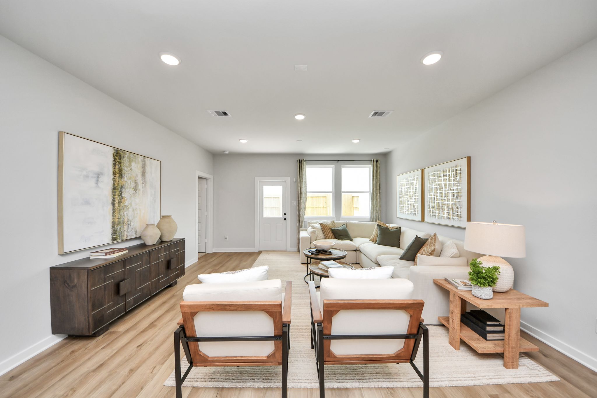 Spacious living room at Robins Landing in Houston, Texas, featuring modern furniture, light wood floors, and neutral decor.