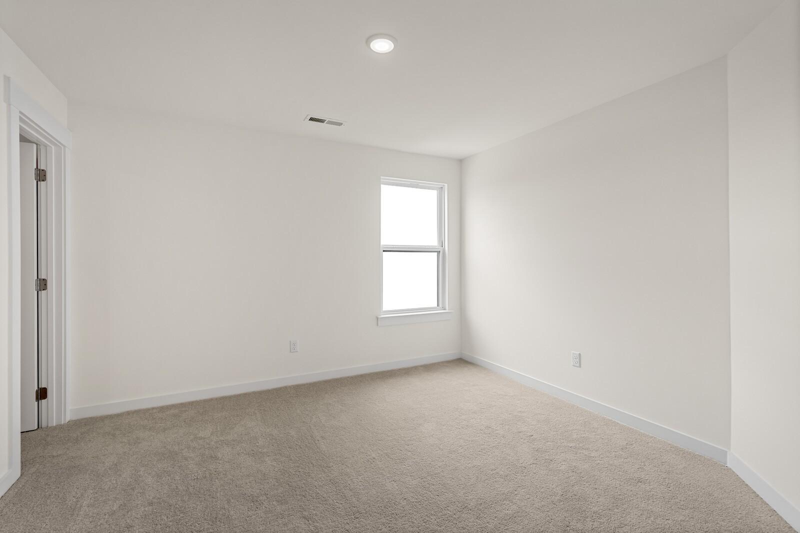 Bright, neutral bedroom with plush carpeting in The Ridgeport D floor plan at Benders Cove, Mt. Juliet, Tennessee.