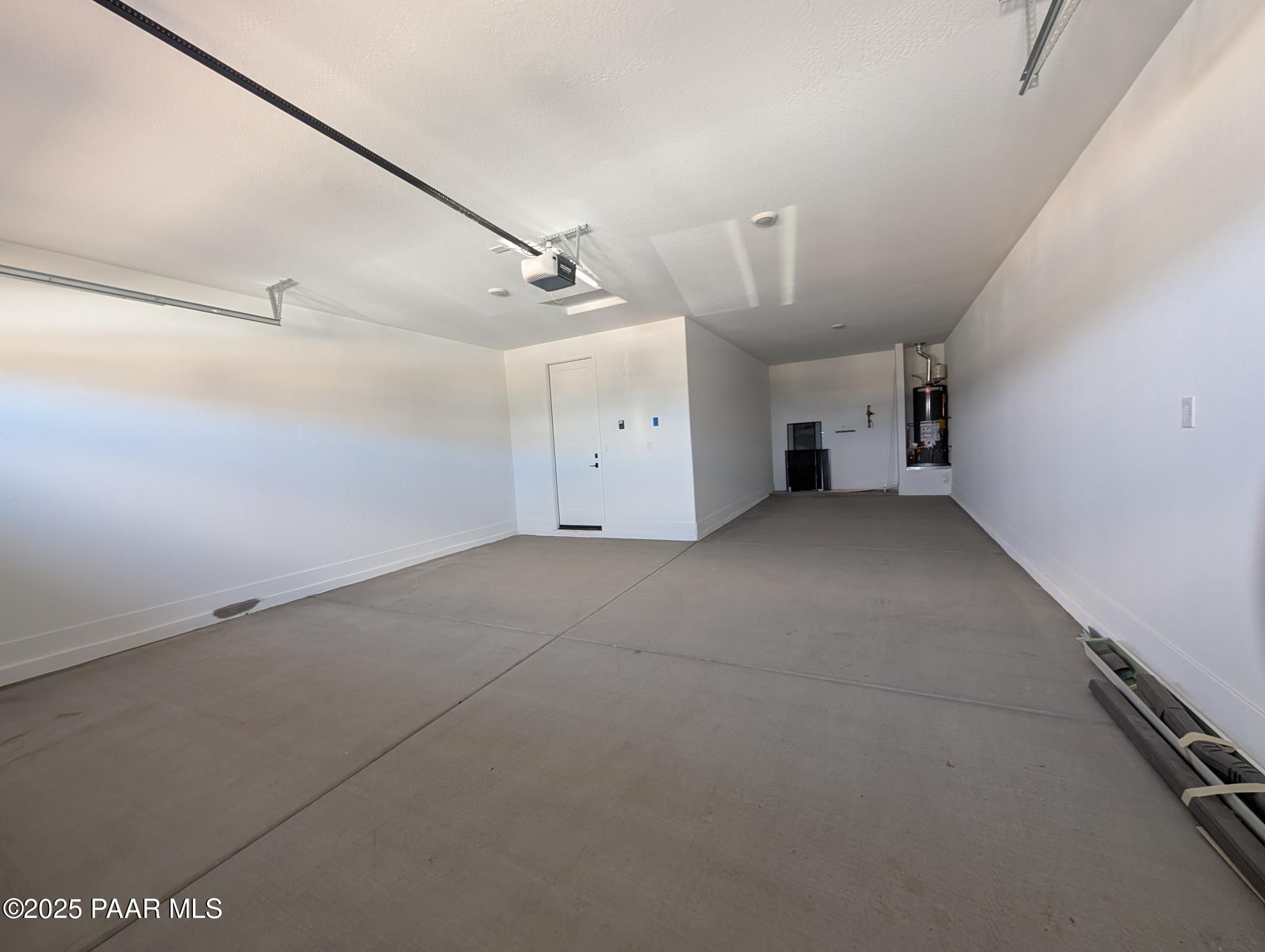 Spacious 3-car garage with concrete floor, storage cabinets, and utility area in Davidson Homes The Sheridan II F, Prescott, Arizona