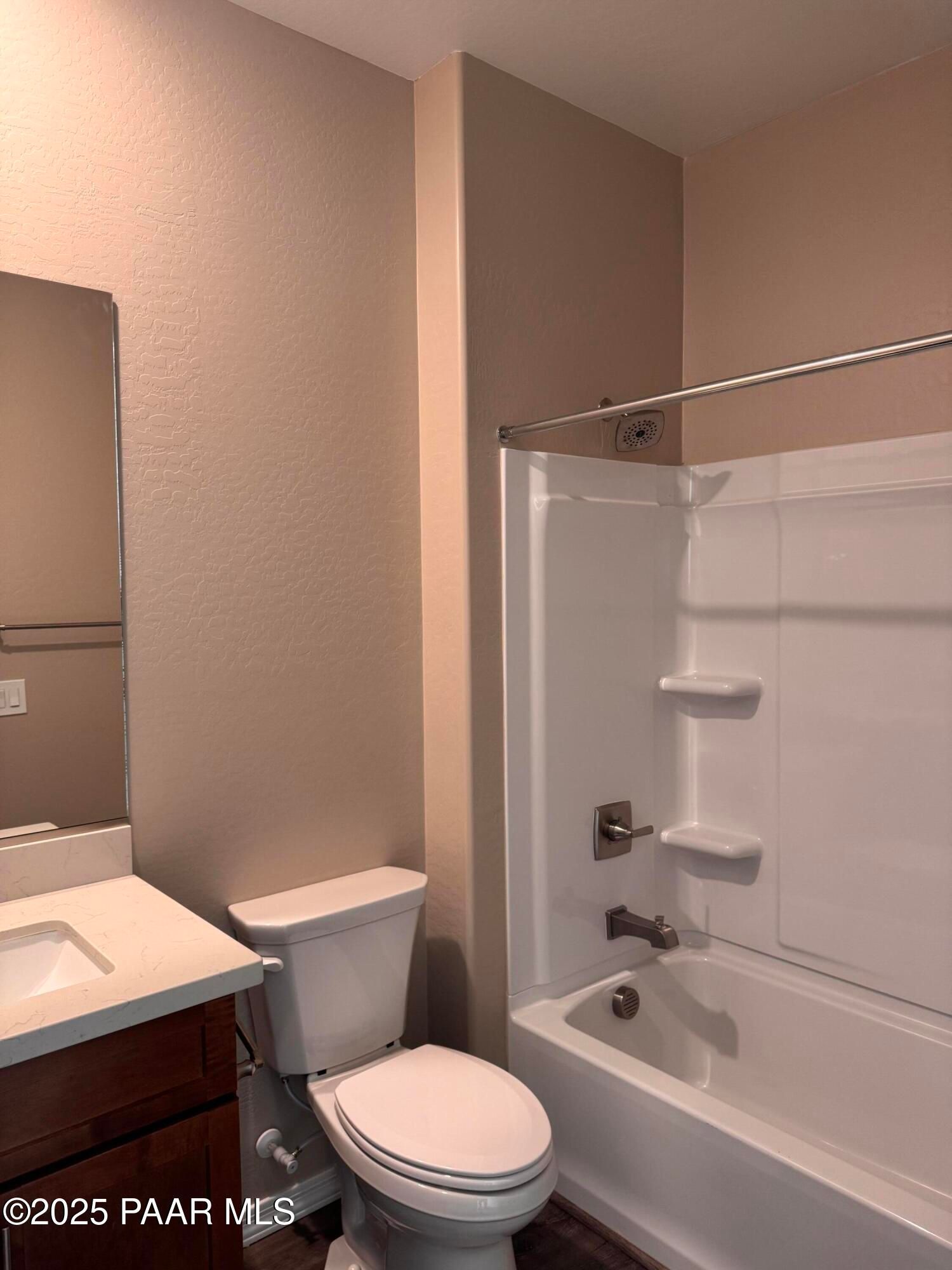 Modern bathroom featuring white bathtub-shower combo, quartz vanity, and toilet in Davidson Homes The Sunrise II A, Prescott Arizona