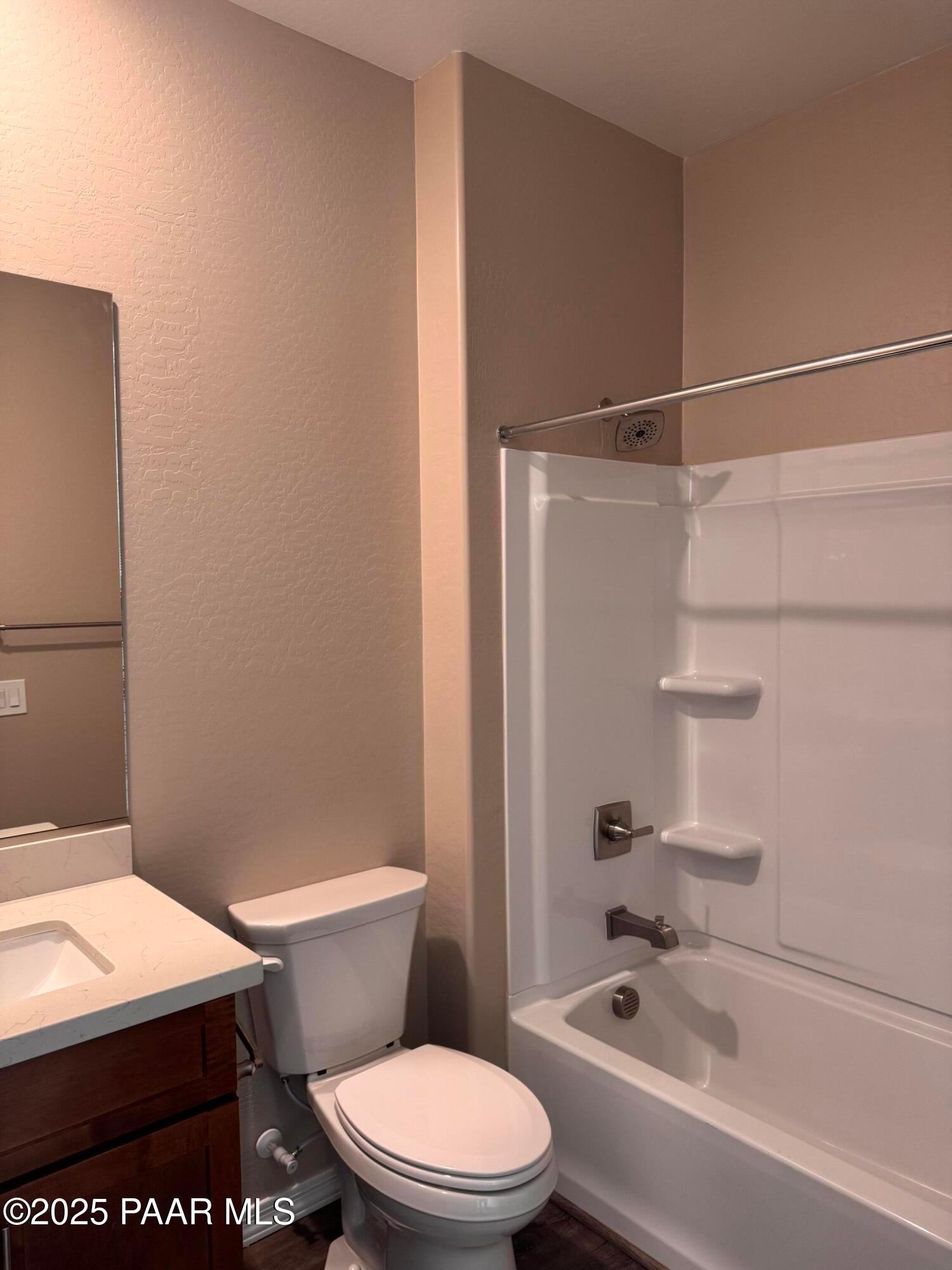 Modern bathroom featuring white bathtub-shower combo, quartz vanity, and toilet in Davidson Homes The Sunrise II A, Prescott Arizona