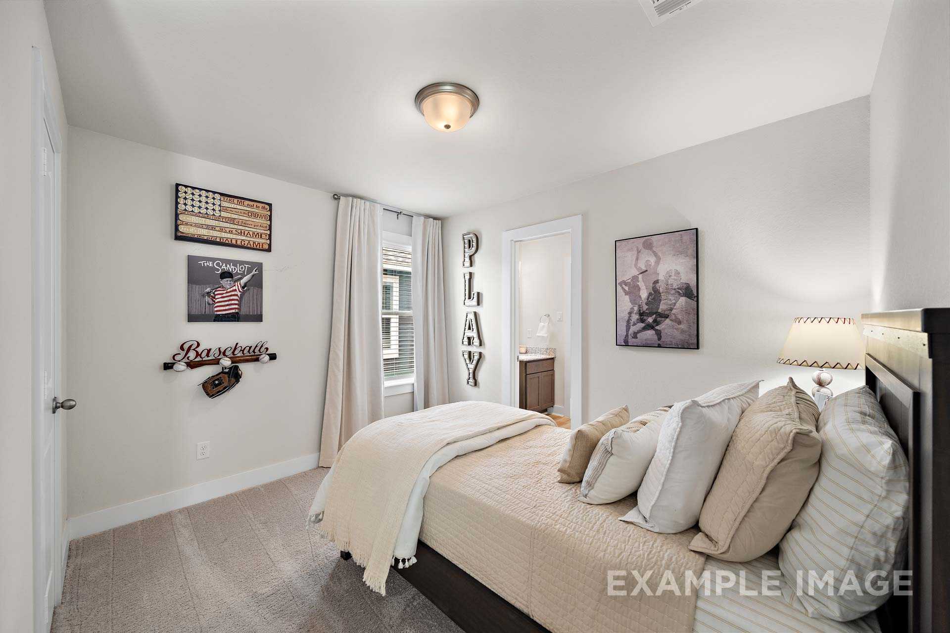 Cozy boy's bedroom in The Lily A home by Davidson Homes, Cypress TX: baseball decor, plush bed, sheer curtains, soft lighting