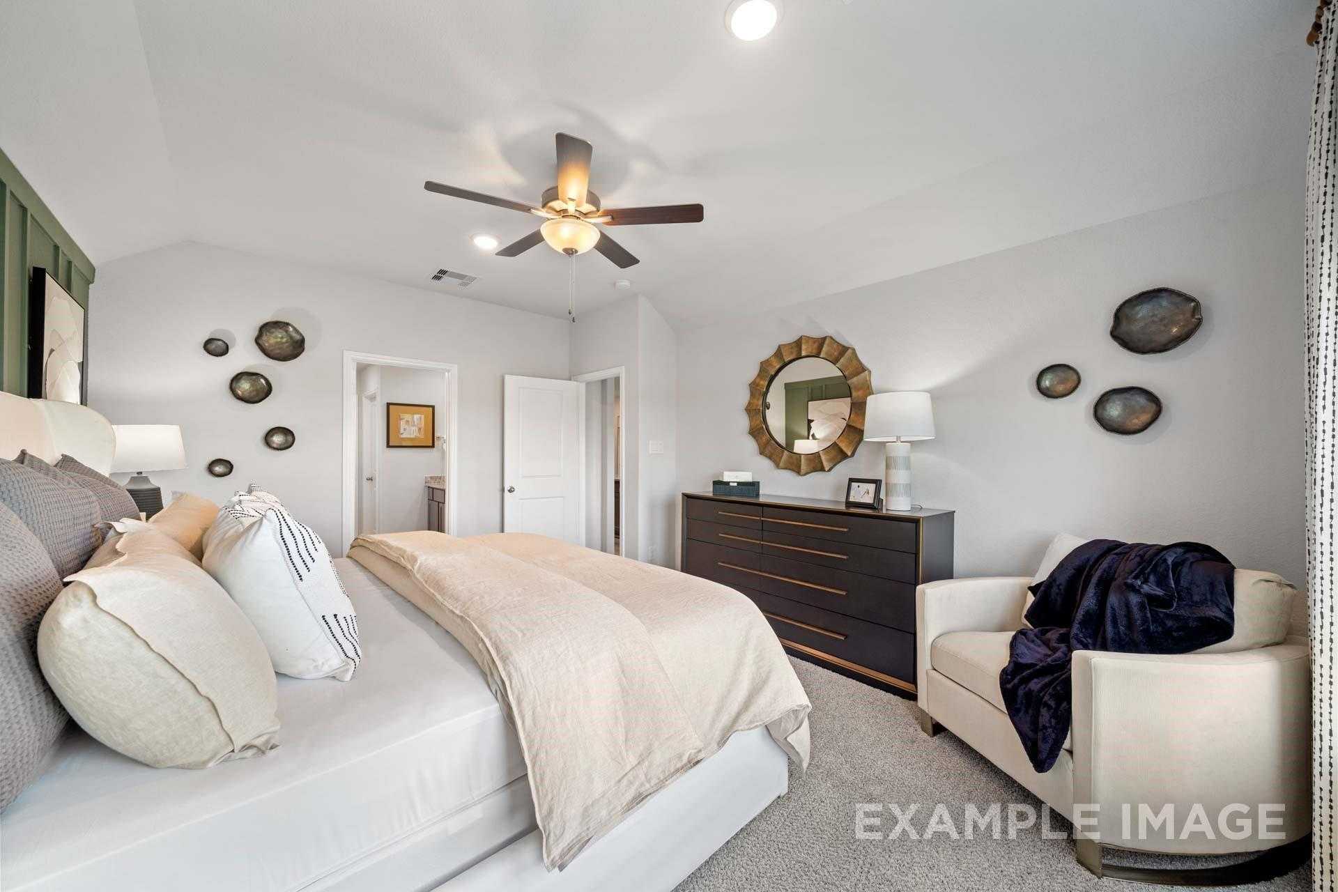 Luxurious master bedroom with king bed, ceiling fan, gold mirror, and en-suite door in Davidson Homes The Acadia A, Texas City