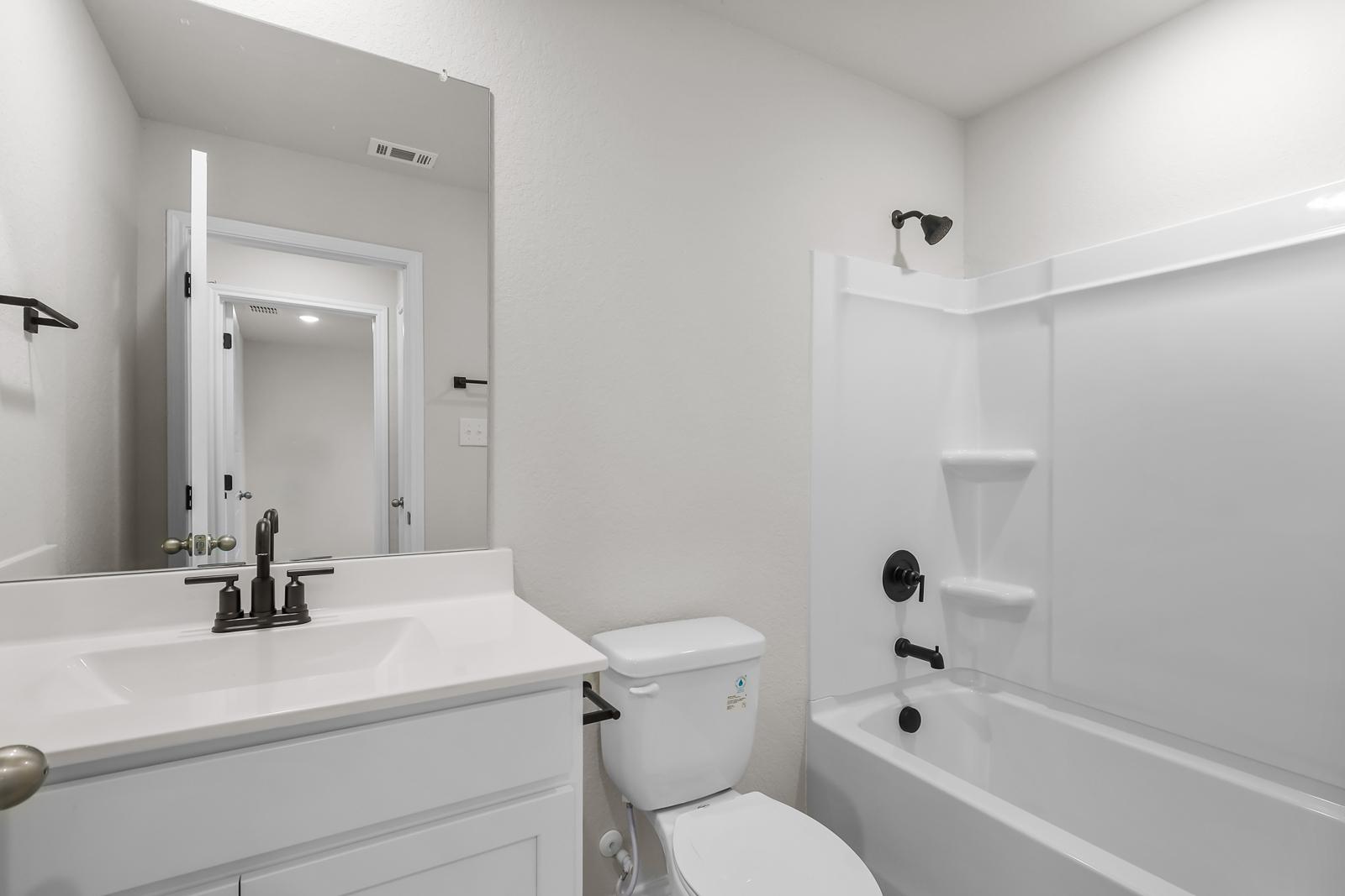 Full bathroom in The Sequoia C featuring white vanity, modern matte black fixtures, and a shower-tub combination.