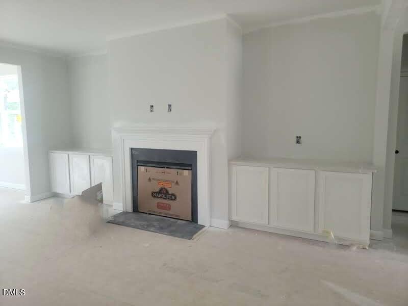 Spacious great room with white fireplace surround and built-in cabinetry in Davidson Homes Crawford D plan, Angier, NC